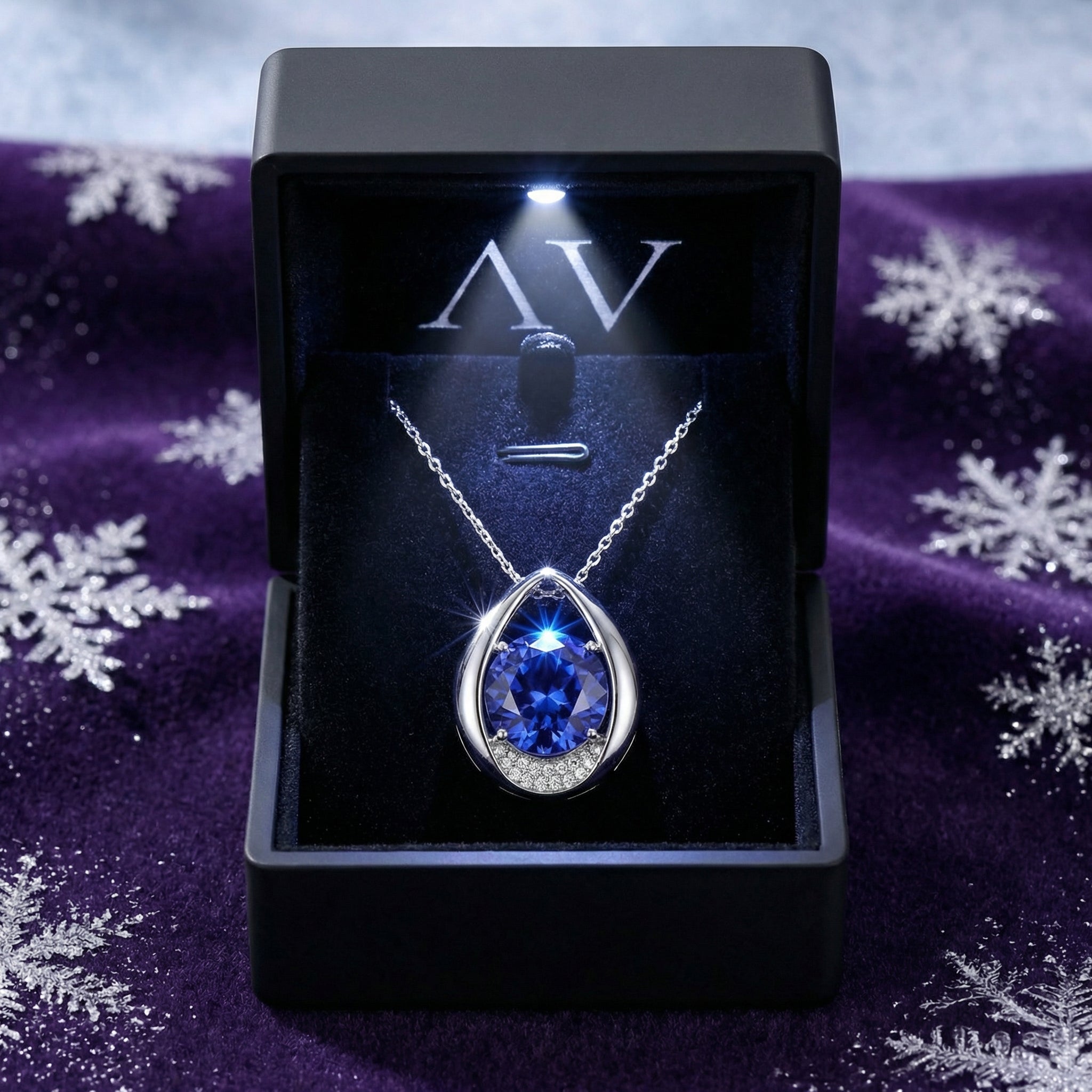 Teardrop sterling silver simulated tanzanite necklace presented in a black LED-lit gift box on purple velvet.
