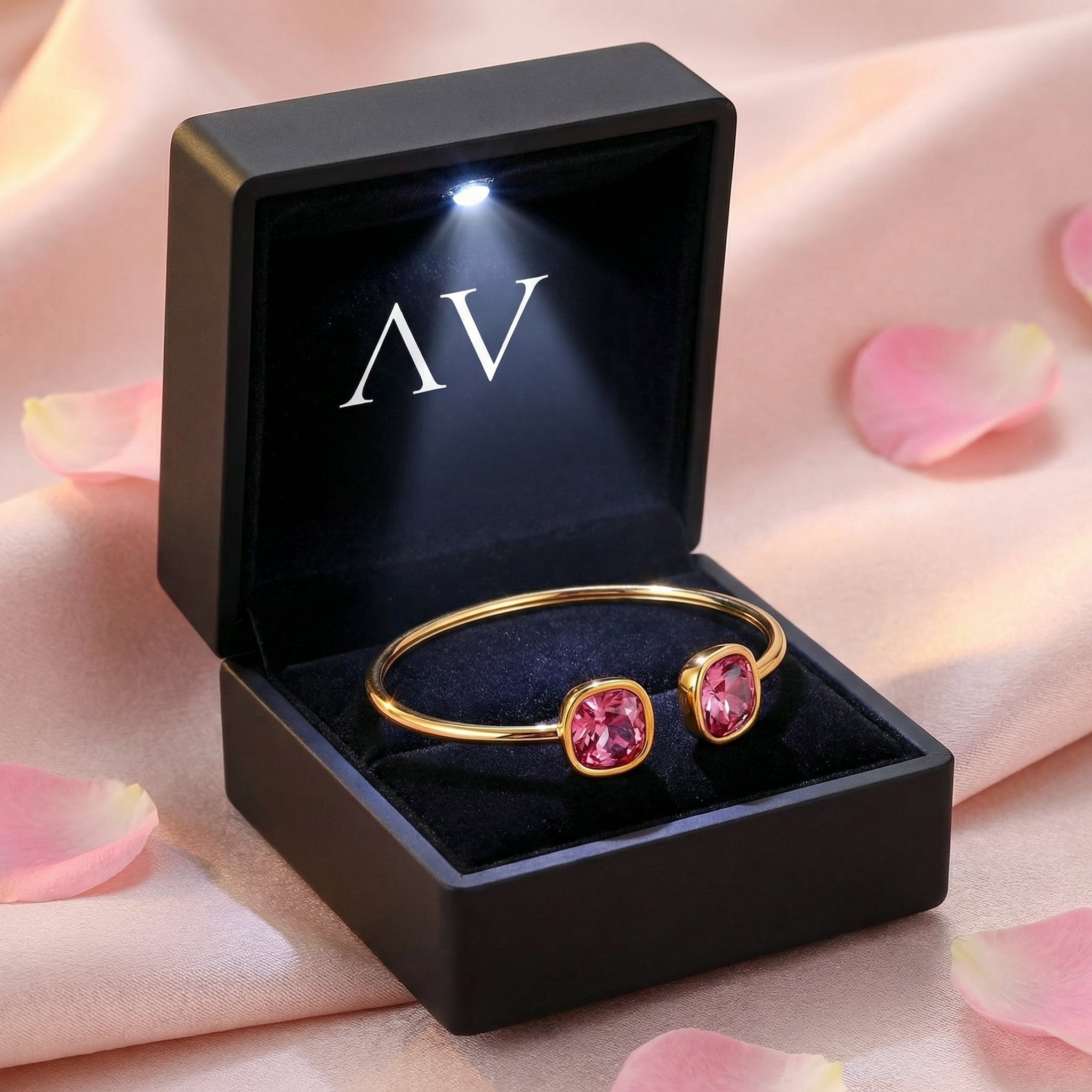 Gold-toned stainless steel pink tourmaline cuff bracelet inside a black LED-lit jewelry presentation box.