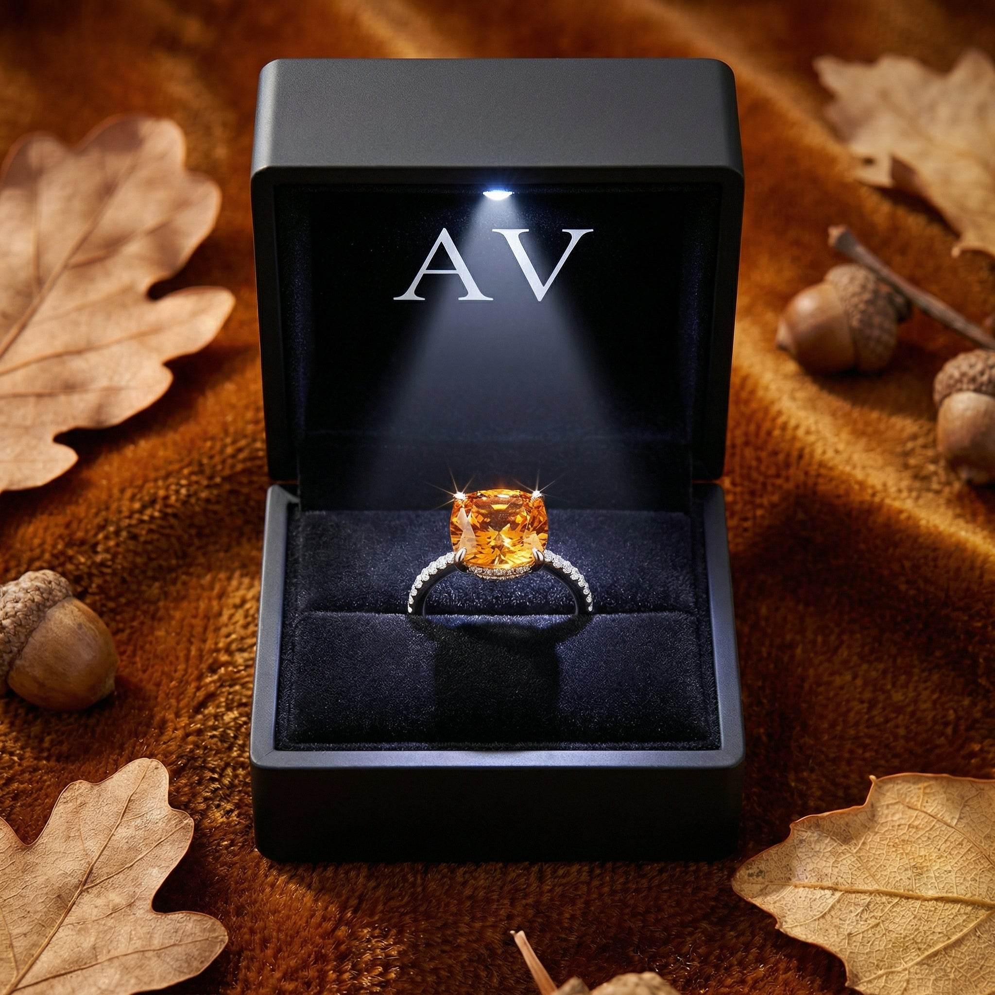 Cushion cut simulated topaz ring in S925 sterling silver inside a lit black jewelry box with autumn leaves.