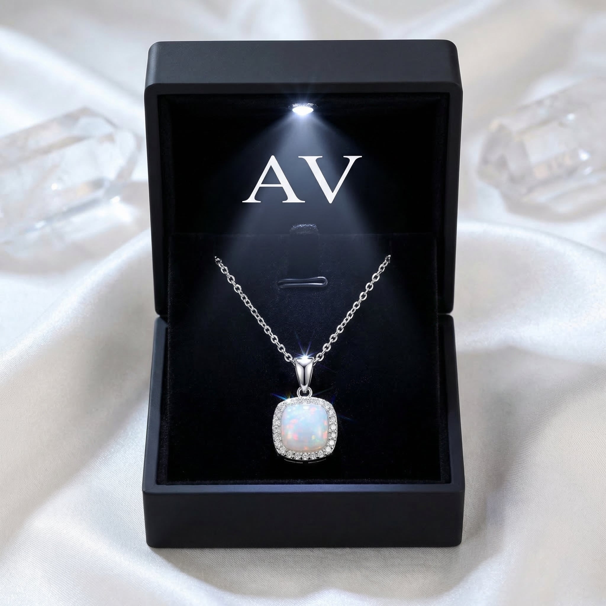 Silver cushion cut white opal halo pendant necklace in a black LED-lit jewelry gift box.
