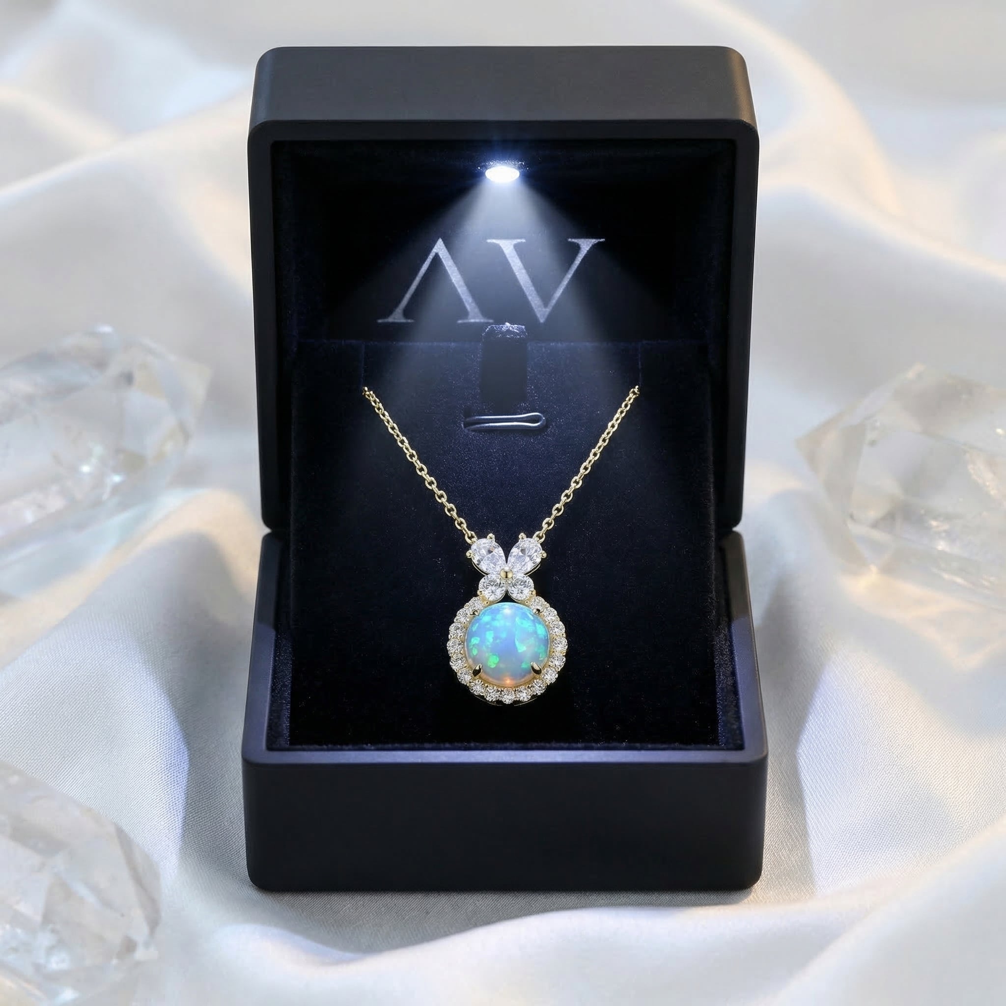 Gold vermeil blue opal necklace displayed in a black LED-lighted jewelry box on white silk fabric.