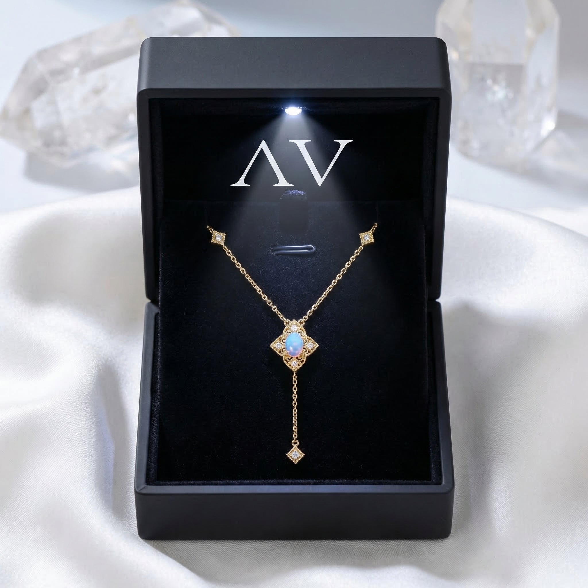 Gold-tone white opal lariat necklace presented in a premium black lighted jewelry gift box.