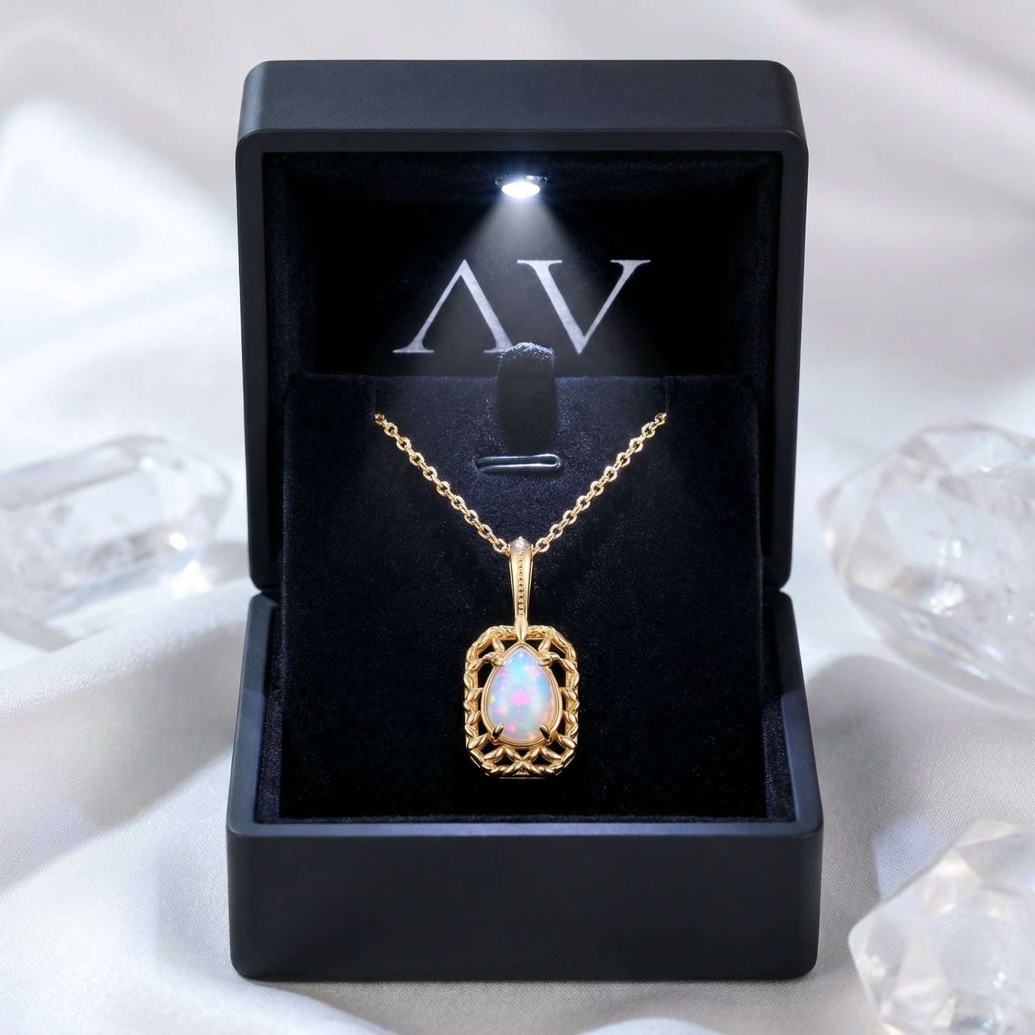 Gold-finished pear-cut opal necklace displayed in a premium black gift box with an integrated LED light.
