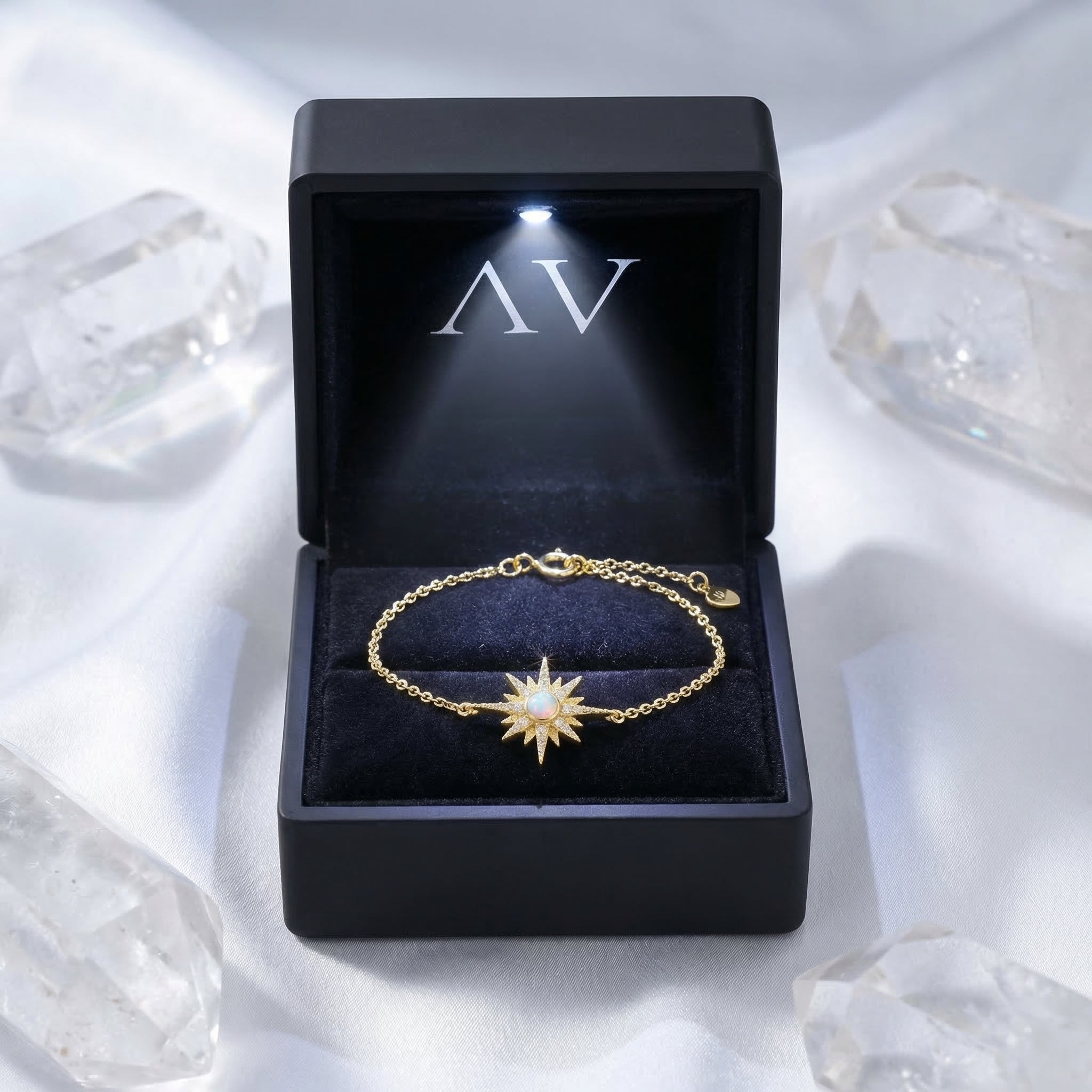 Gold-tone sterling silver Elowen starburst opal bracelet with a round-cut stone in a lighted jewelry box.