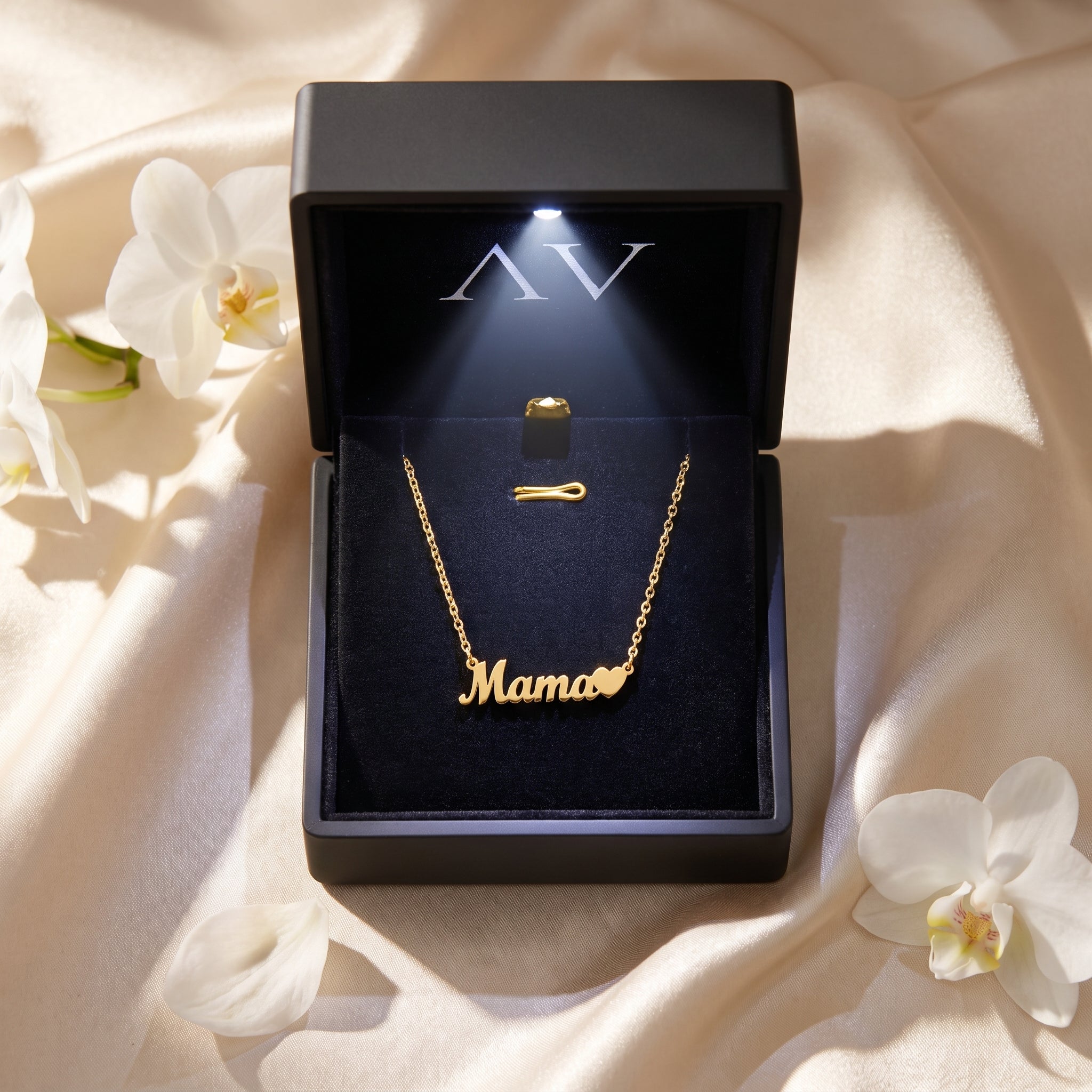 18K gold finish Mama script necklace displayed inside a lighted black jewelry gift box.