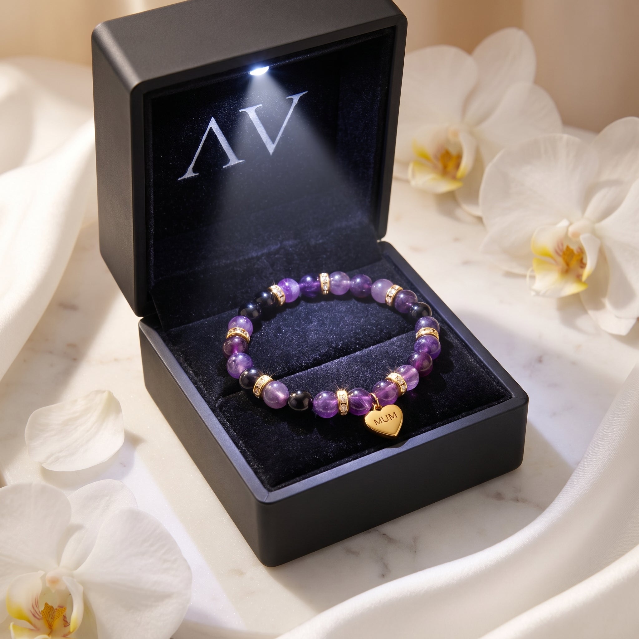Amethyst beaded bracelet with gold heart charm in a black LED gift box.