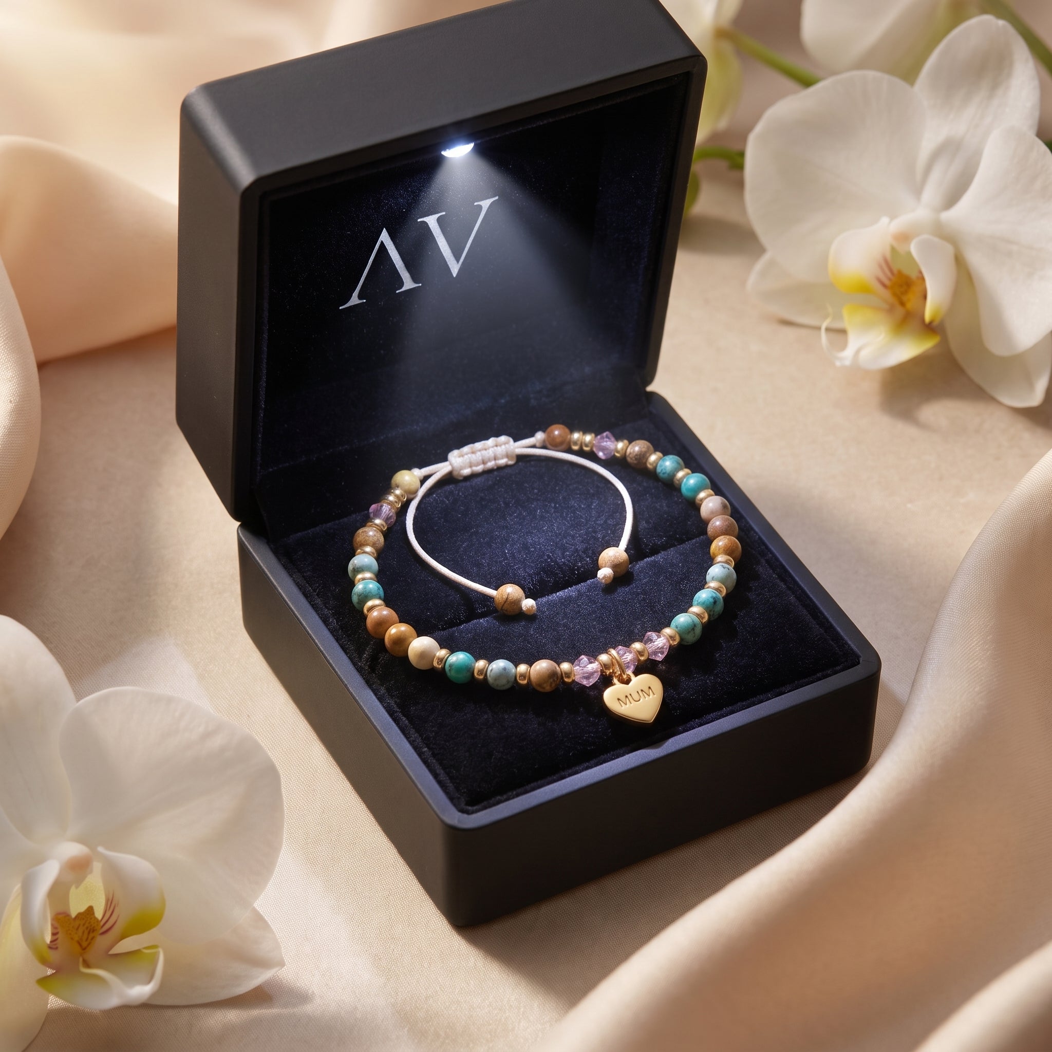 18K gold MUM heart bracelet in a black LED-lit presentation box.