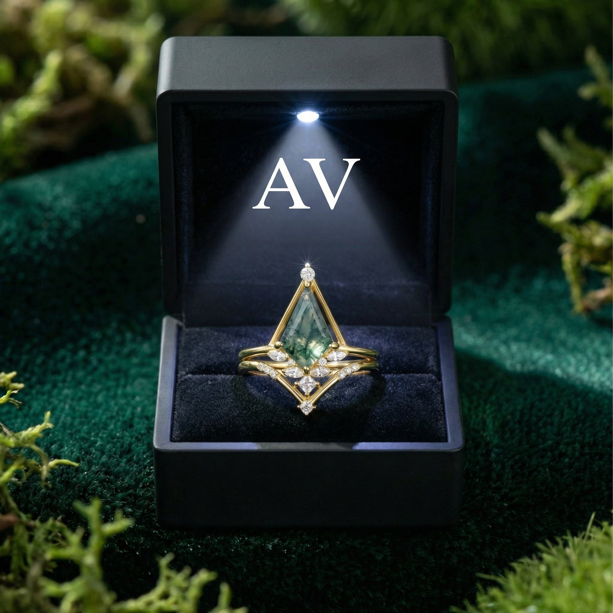 Triangular moss agate ring set in gold-plated sterling silver inside a black lighted jewelry presentation box.