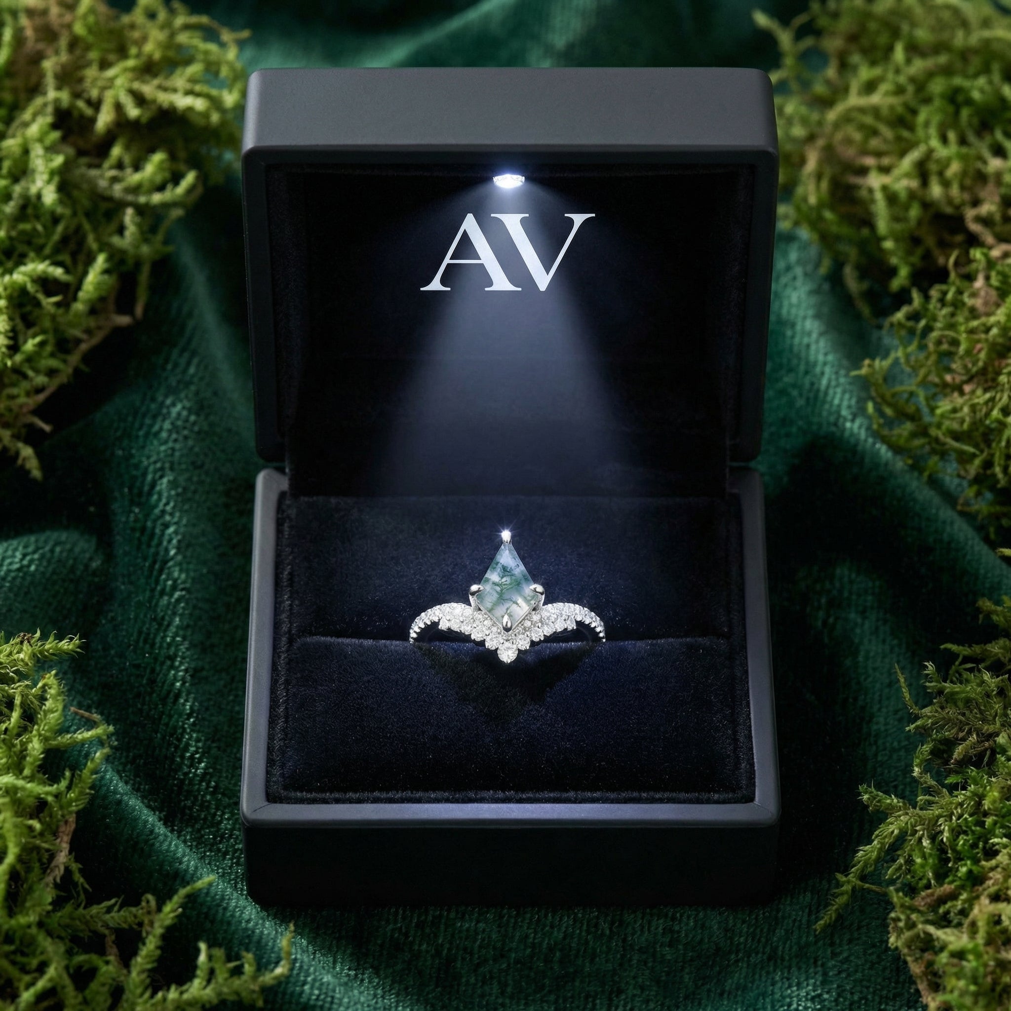 Kite cut moss agate S925 sterling silver ring presented in a black LED-lit gift box on a bed of green moss.