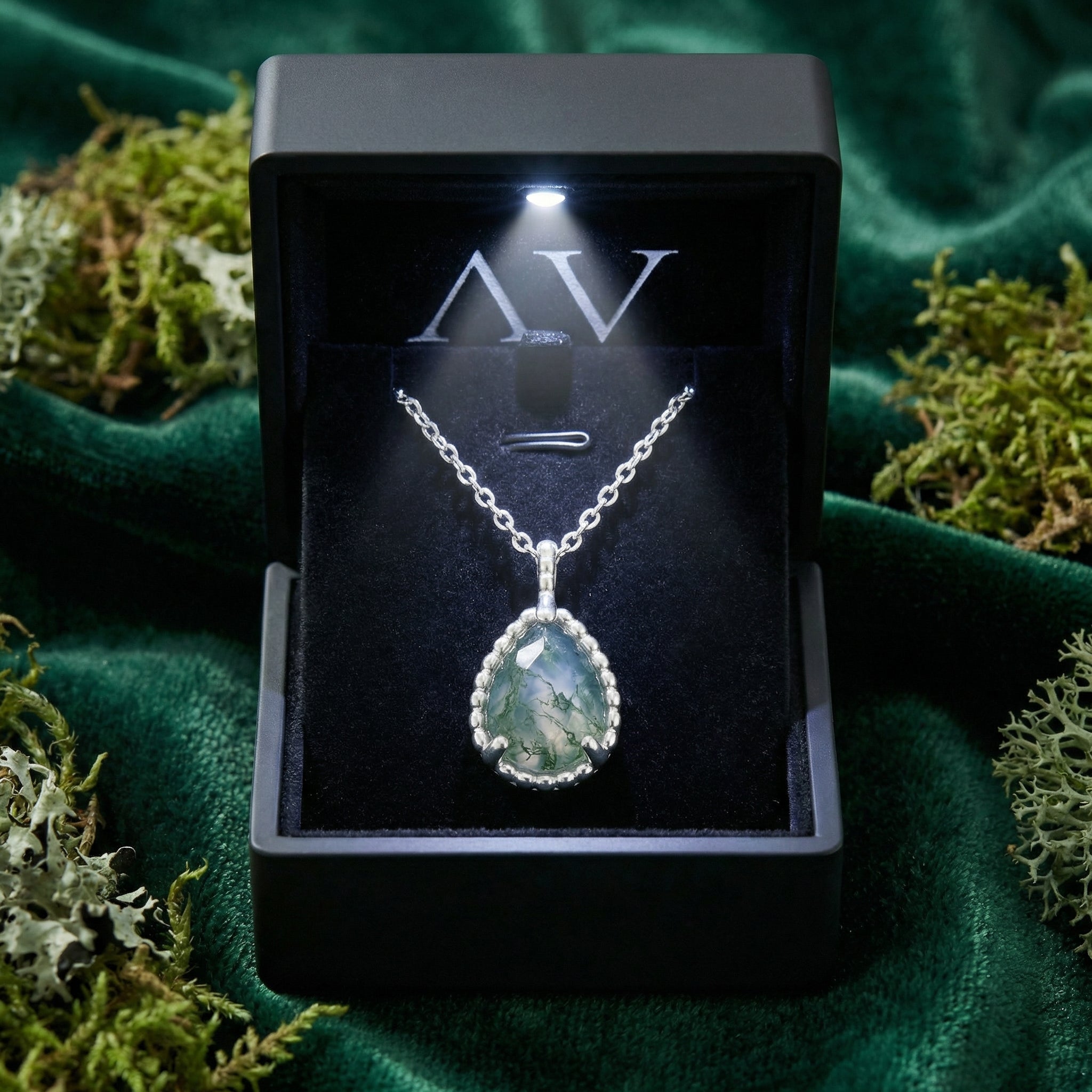Teardrop moss agate basket weave necklace in sterling silver in a lighted black gift box with moss.
