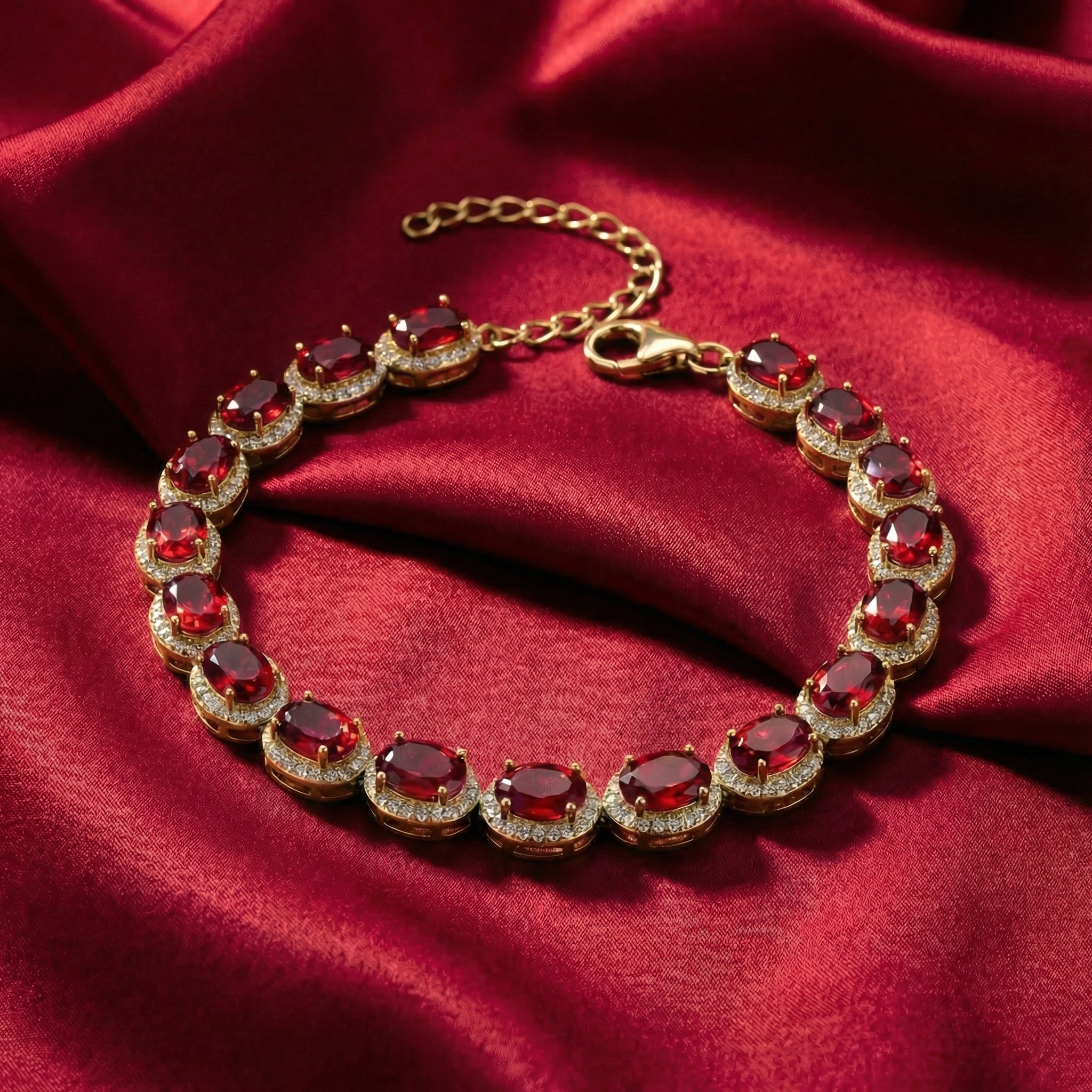 The Bellara oval simulated ruby tennis bracelet in solid yellow gold.