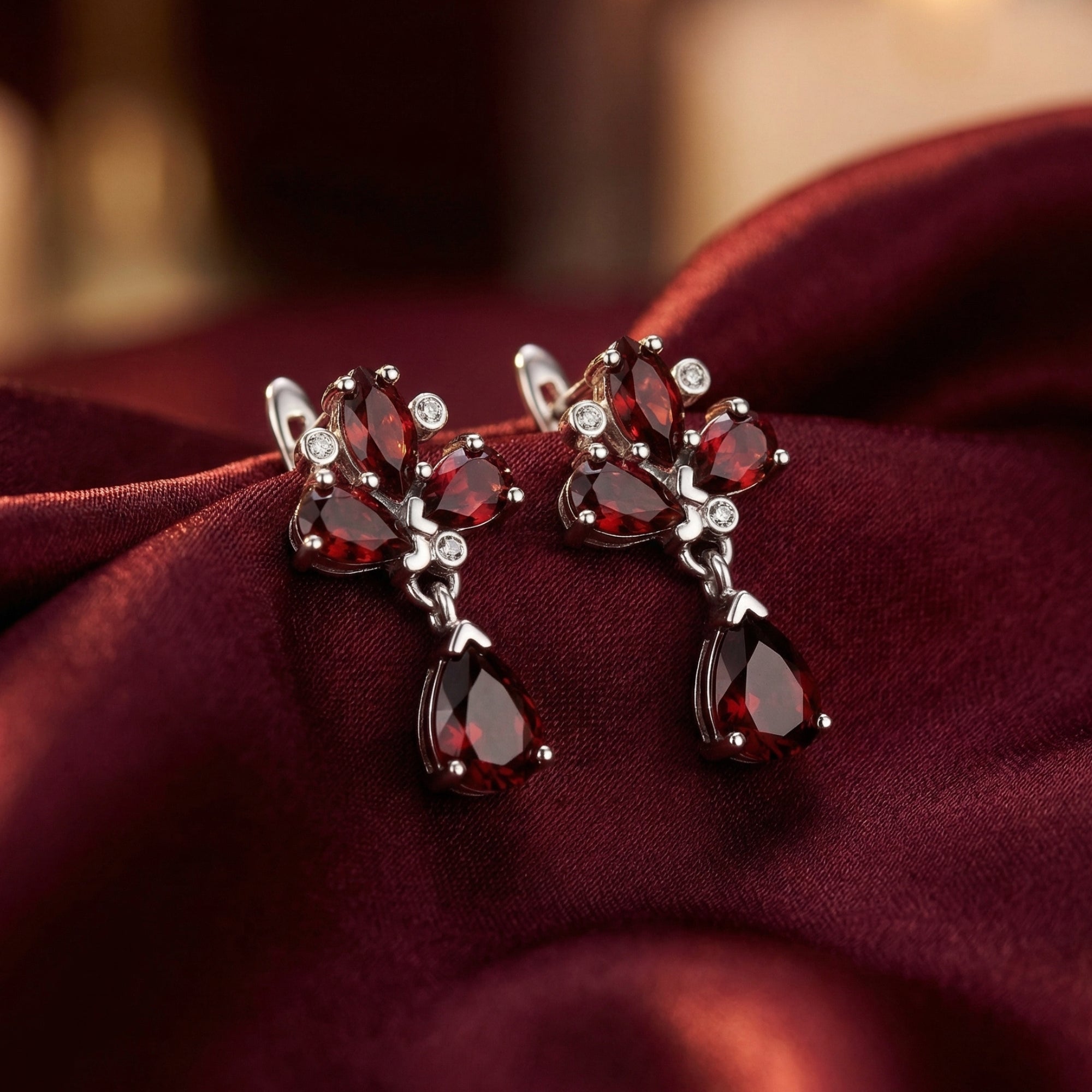 Fiamma cluster earrings in silver with pear and marquise cut natural garnets on burgundy silk.