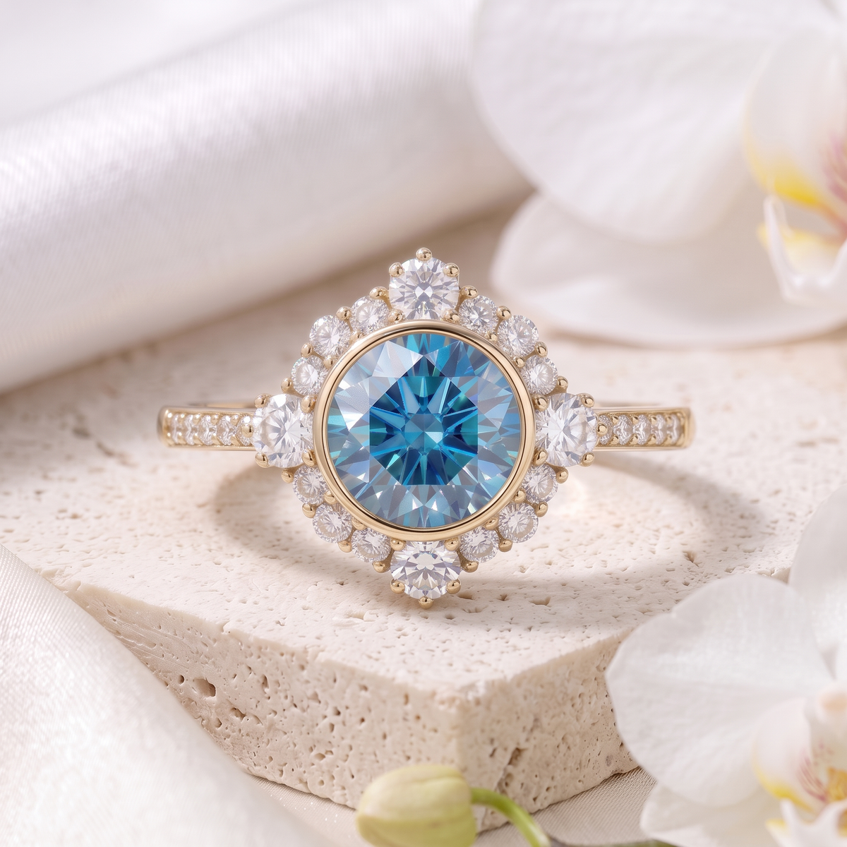 Front view of a round blue moissanite vintage halo engagement ring in yellow gold on a stone block.