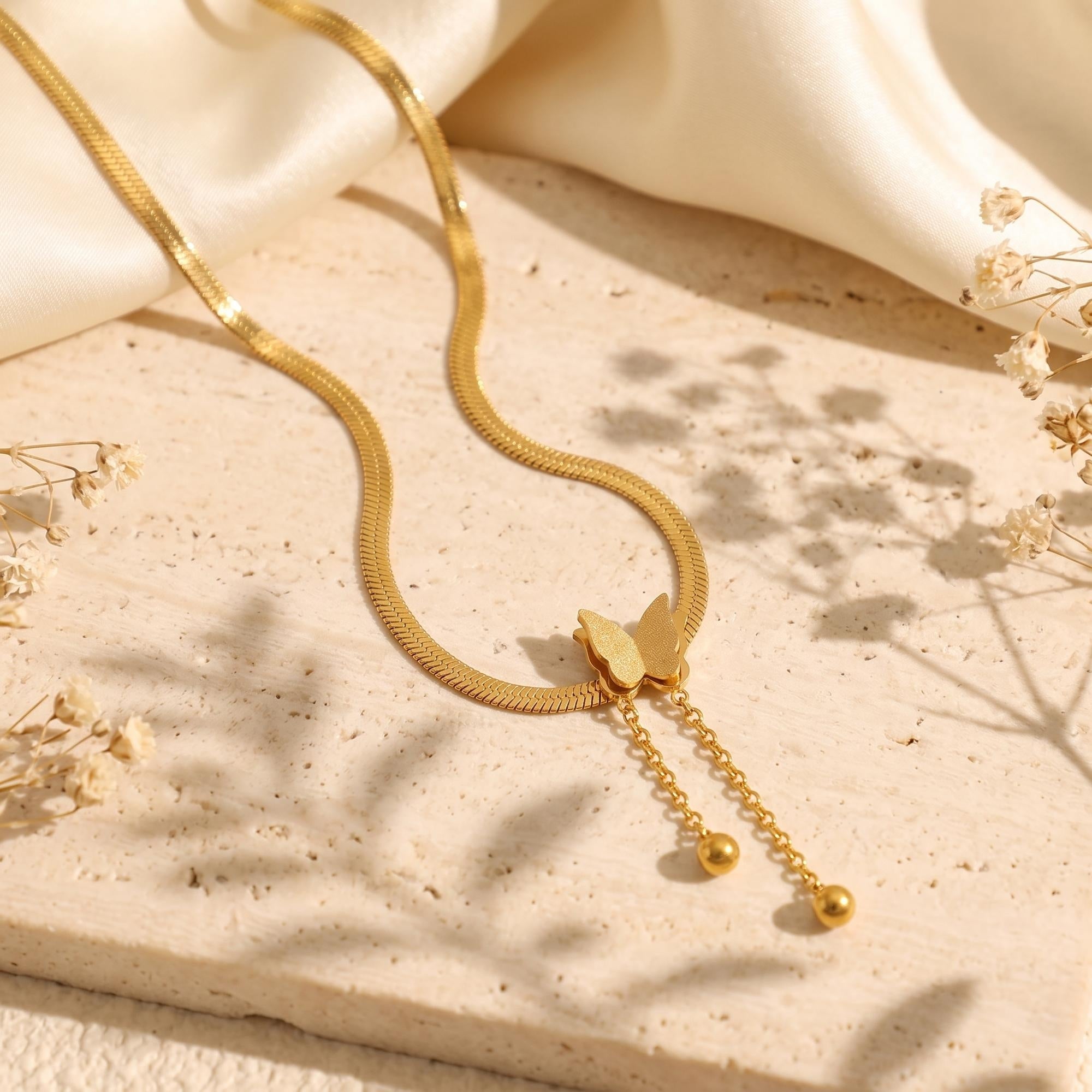 Le collier à pampilles et pendentif papillon