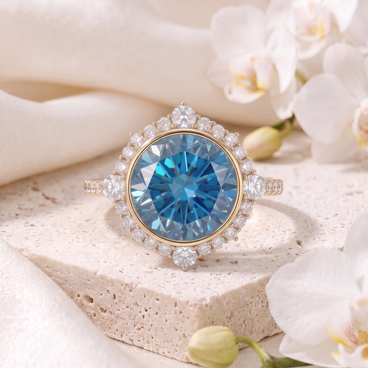 Round blue moissanite halo engagement ring in yellow gold on a stone pedestal.