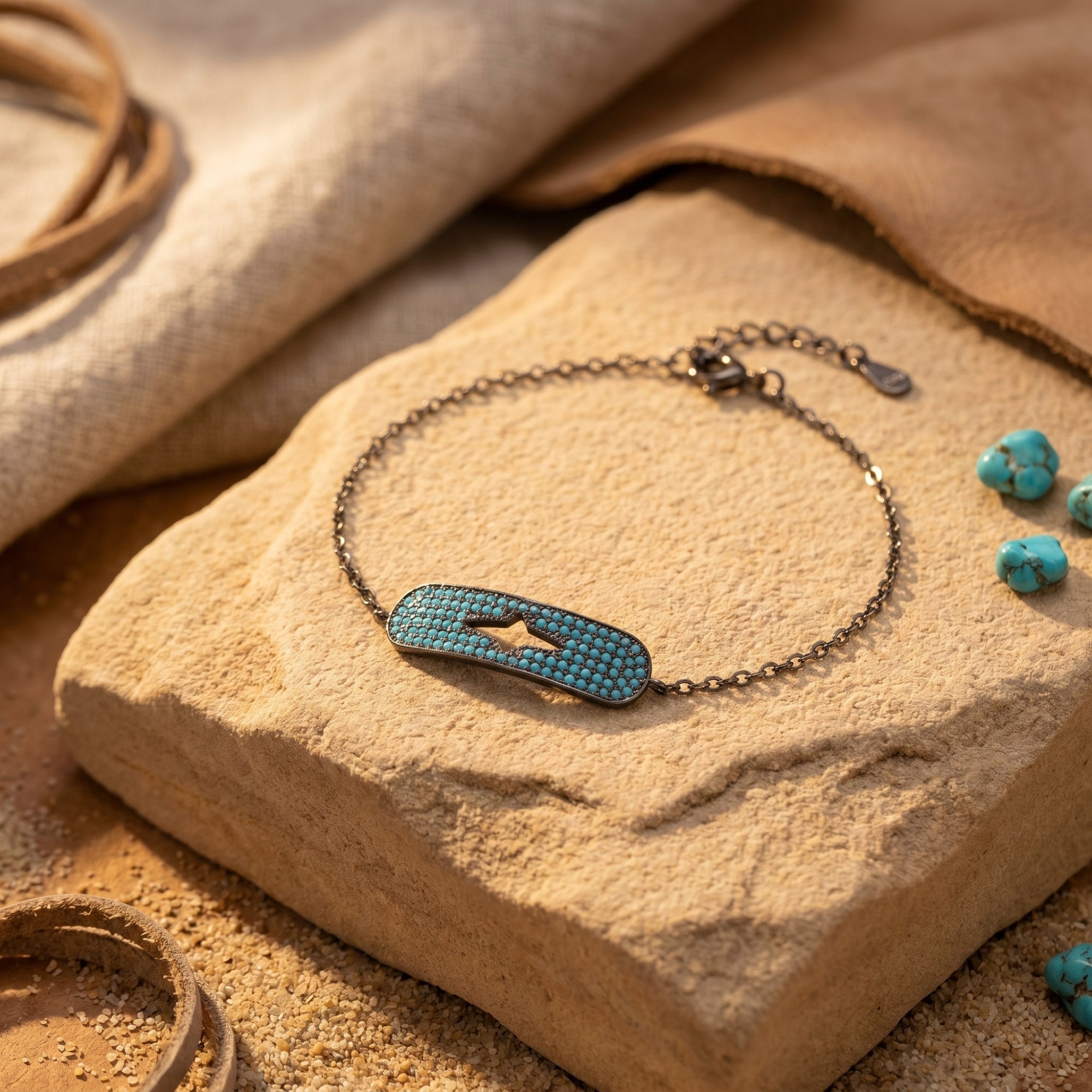 Estrella turquoise bracelet in oxidized S925 sterling silver with a star cutout, resting on a textured desert stone.