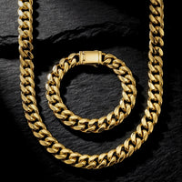 Top view of a 10mm gold Vermeil over S925 Sterling Silver Cuban link chain and bracelet set on a dark textured stone background.
