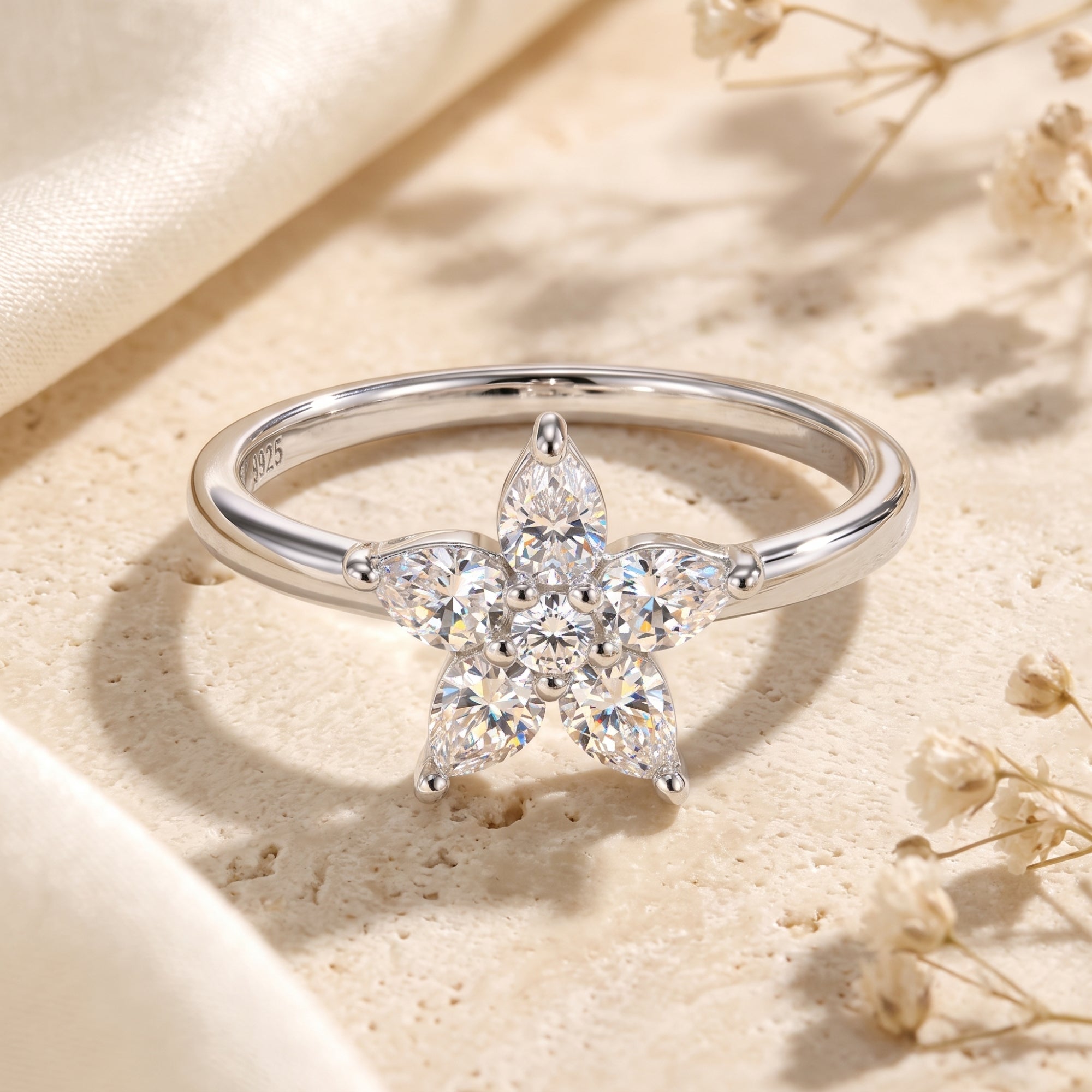 Silver flower cluster ring with pear-cut cubic zirconia in a lifestyle setting.