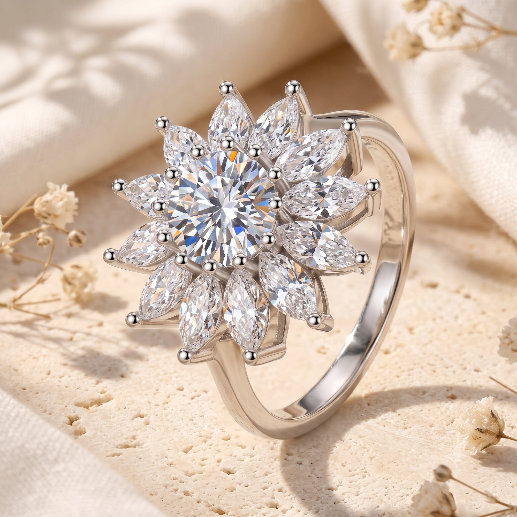 Silver Solar Bloom ring with round and marquise cubic zirconia in a floral sunburst setting on a stone surface.