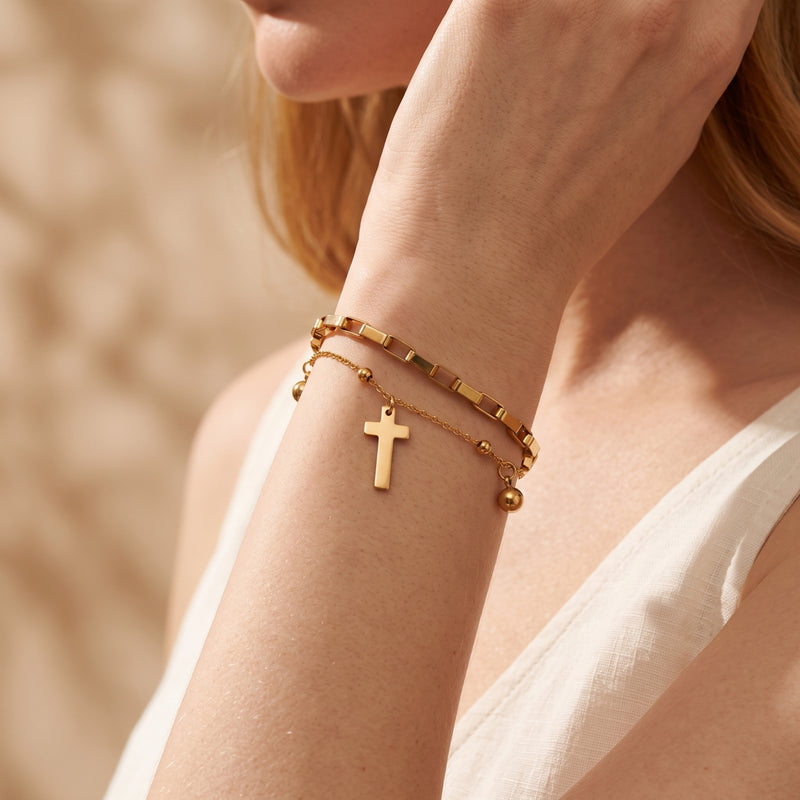 Close-up view of a person wearing the gold double-layer cross bracelet on their wrist.