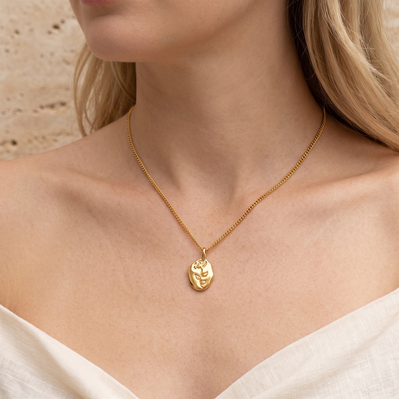 Woman wearing the 18K gold plated Rosianna rose pendant necklace on a thin curb chain.