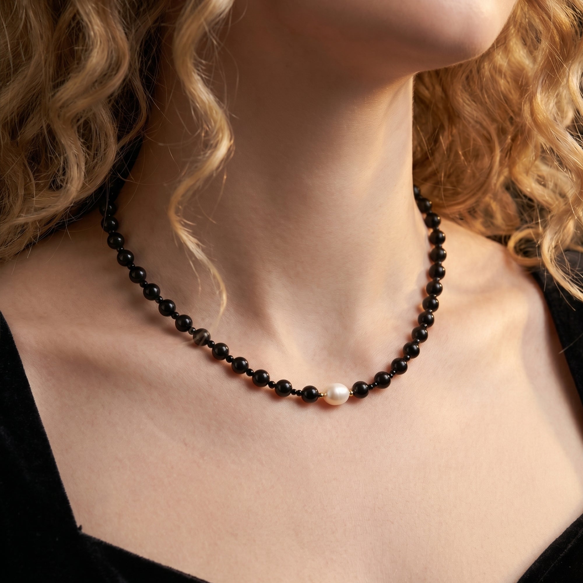 Model wearing the black onyx and white pearl necklace with 18K gold plated beads.
