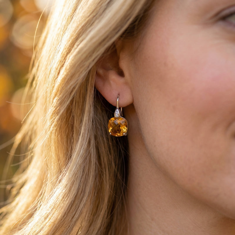 Blonde woman wearing a cushion-cut natural citrine drop earring in silver, showcasing the scale and glow.
