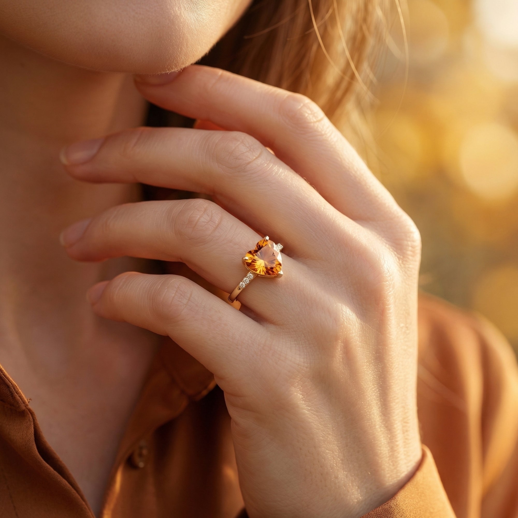Model wearing the Leonora heart cut natural citrine ring in 18K yellow gold on her finger.
