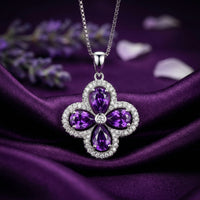 Sterling silver floral pendant with four pear-cut amethysts centered on purple silk with lavender.