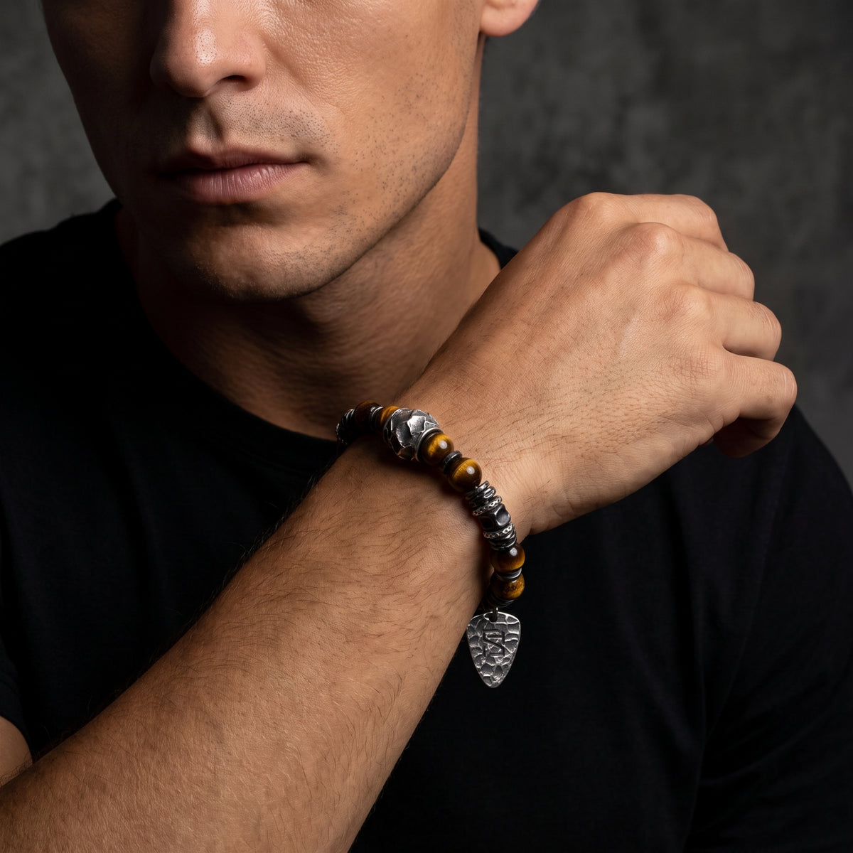 Model wearing the brown tiger's eye and silver beaded bracelet on his wrist with a black shirt.