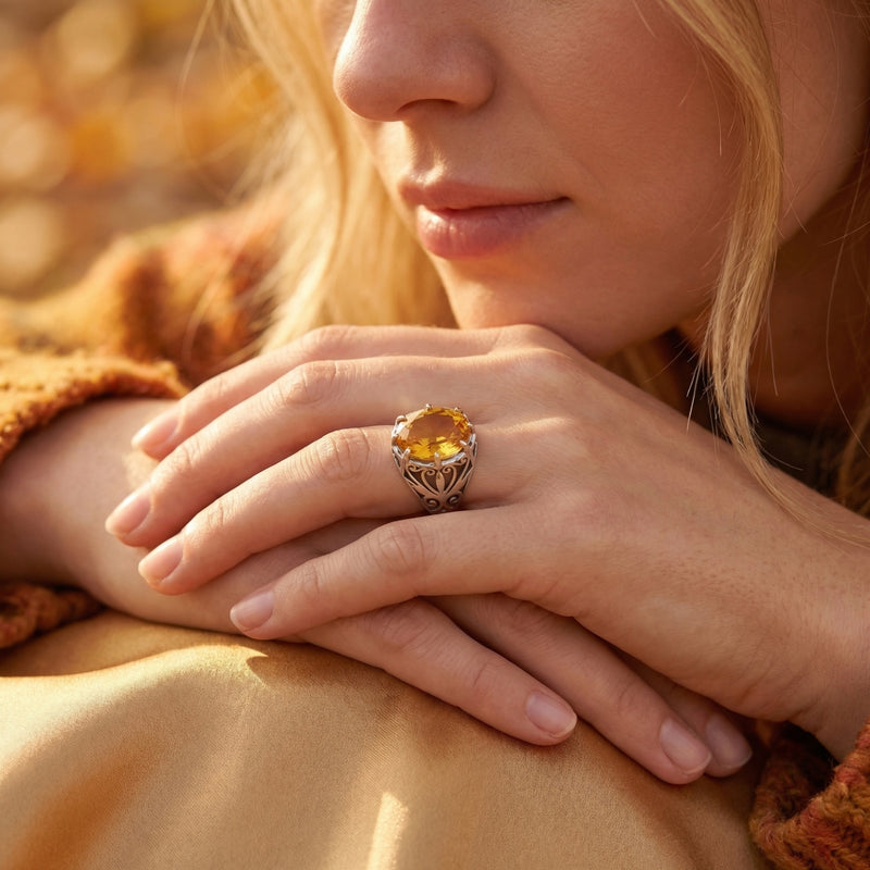 Woman wearing the Solarielle sterling silver ring with a large oval natural citrine on her finger in warm sunlight.