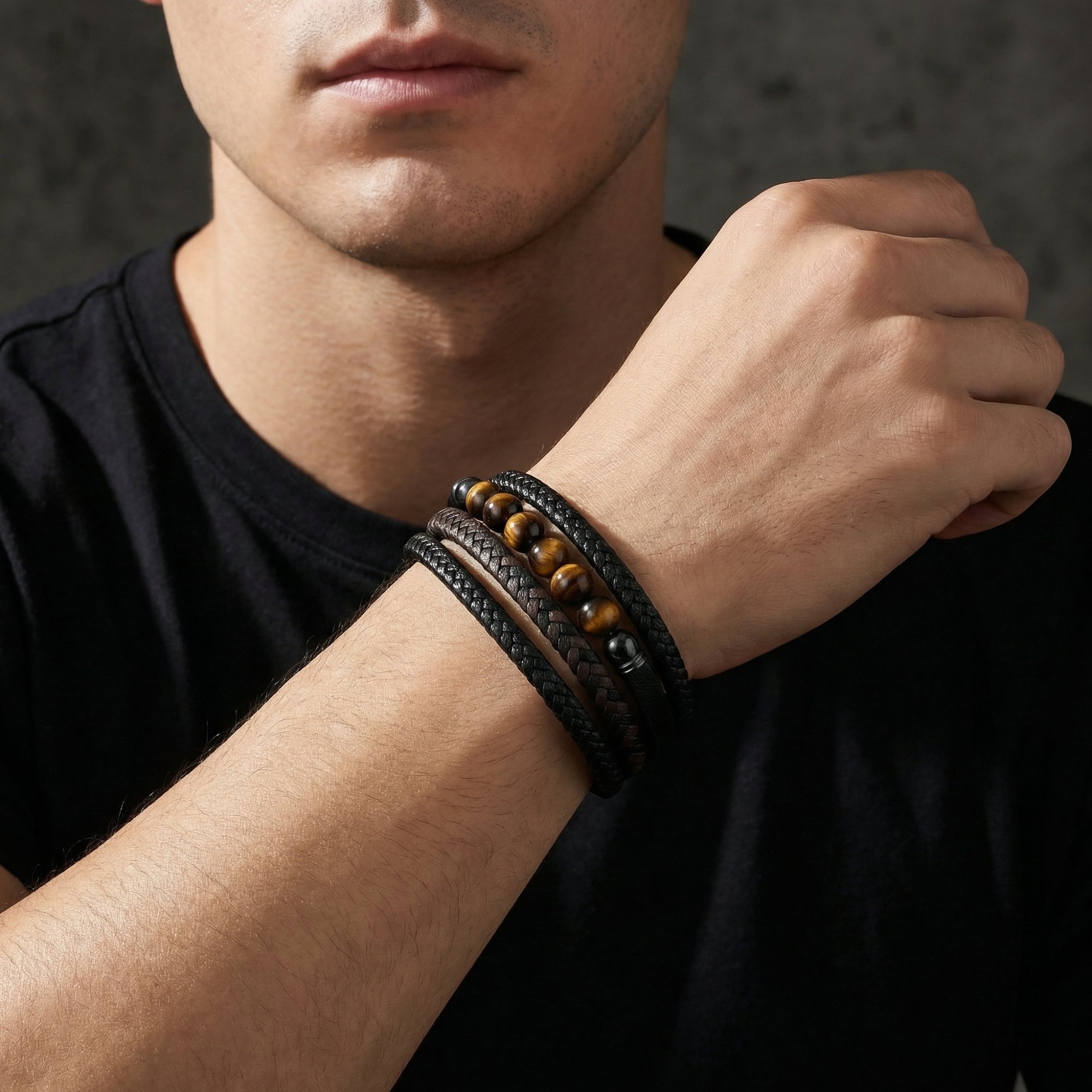 The Garrison men's black leather and tiger's eye bead bracelet worn on a model's wrist.