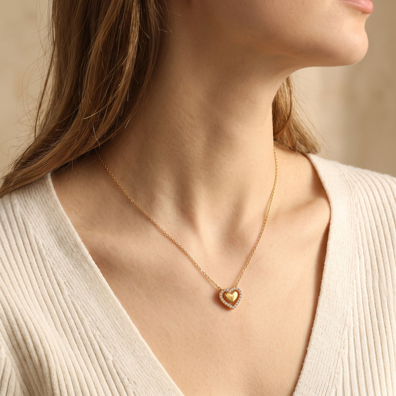Woman wearing the Priscilla gold double heart pendant necklace with shimmering cubic zirconia stones.