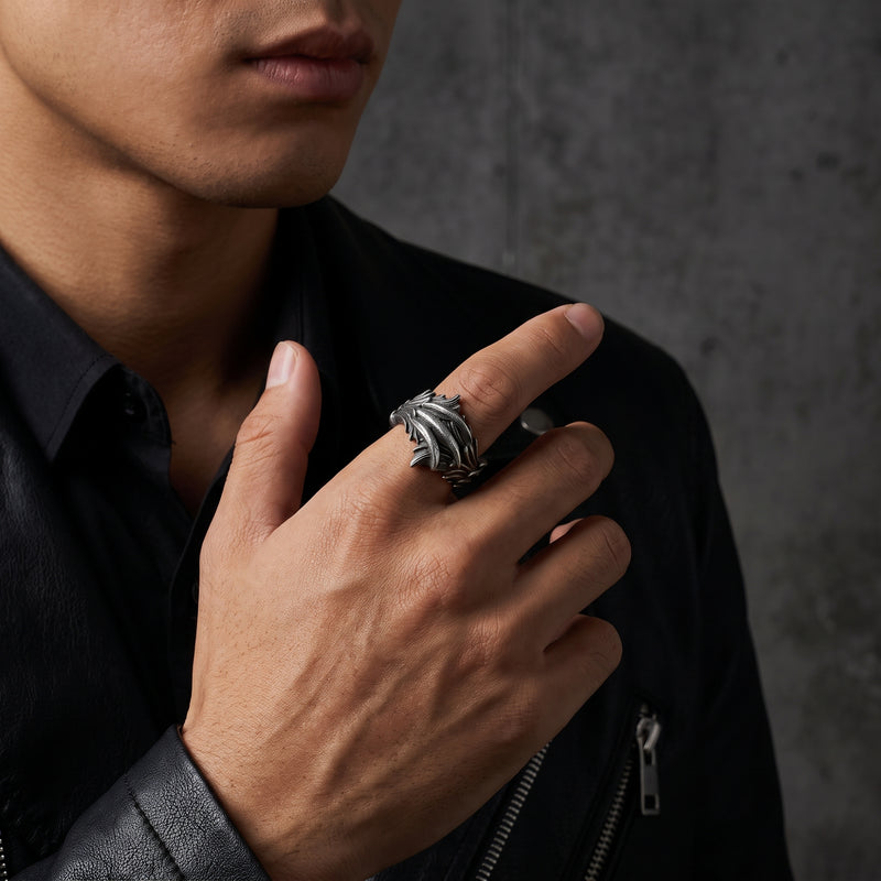 Man wearing the silver feather open band ring on his index finger with a black leather jacket.