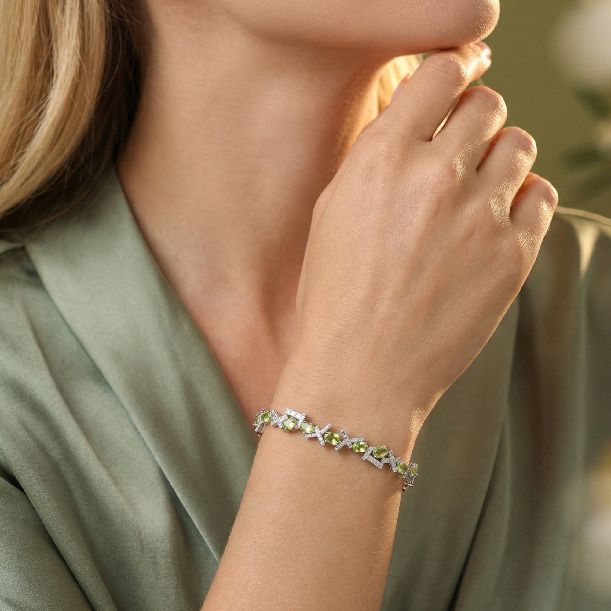 Model wearing the Olyria oval cut green peridot bracelet in sterling silver on her wrist.