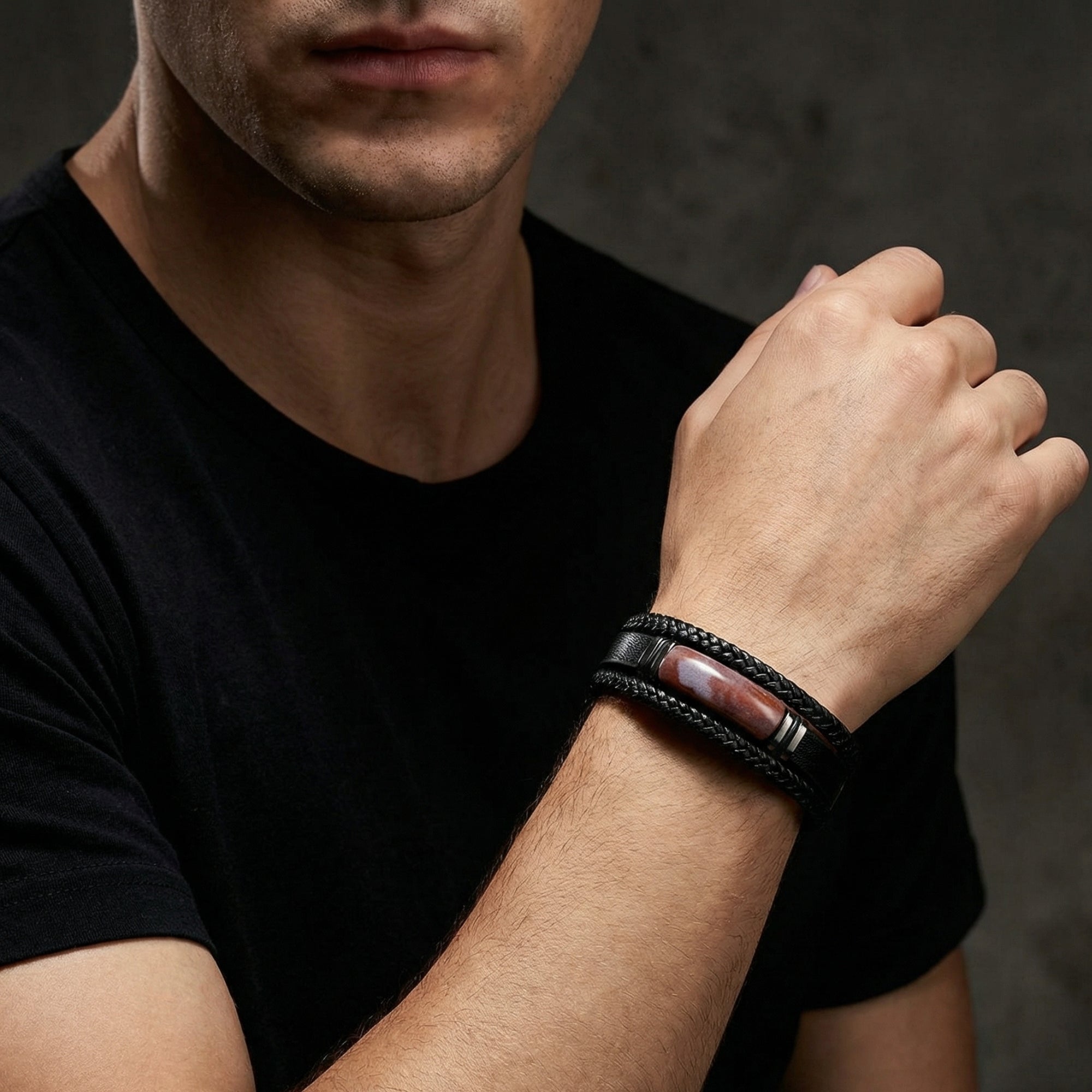 Men's Apex black leather bracelet with a red stone inlay worn on a wrist by a model in a black shirt.
