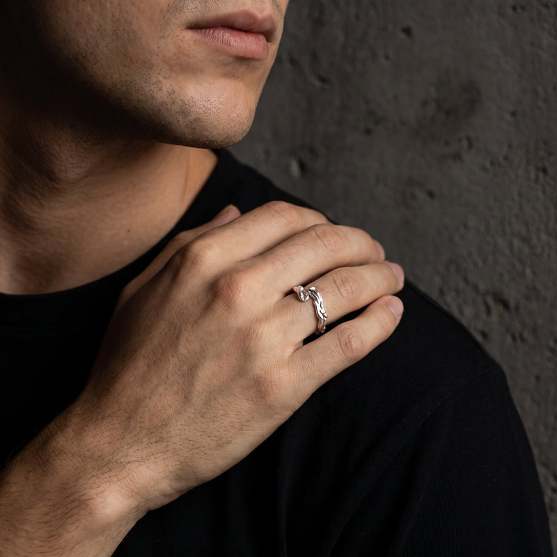 Male model wearing the textured silver open ring on his ring finger while resting his hand on a shoulder.