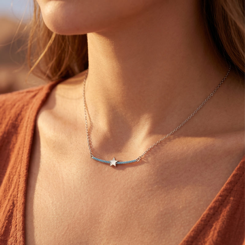 Close-up of a model wearing the silver Phoenix Star turquoise bar necklace against a warm desert backdrop.