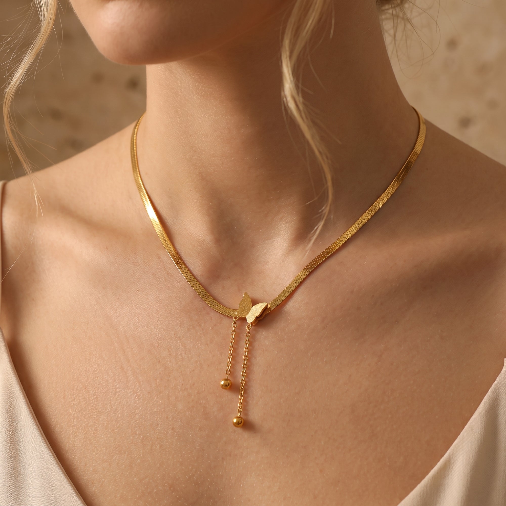 Le collier à pampilles et pendentif papillon
