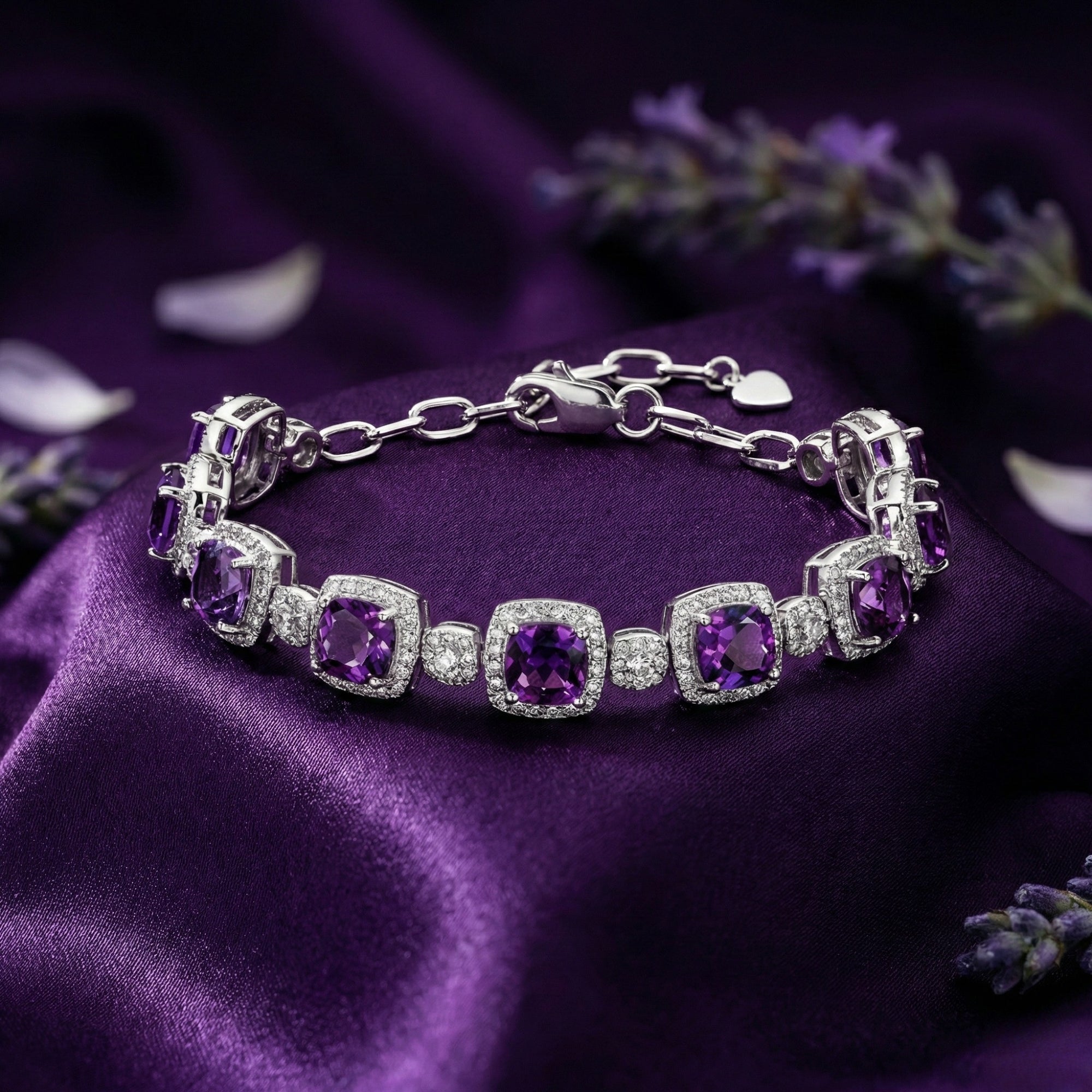 Cushion cut amethyst sterling silver bracelet displayed on purple silk fabric with lavender sprigs.