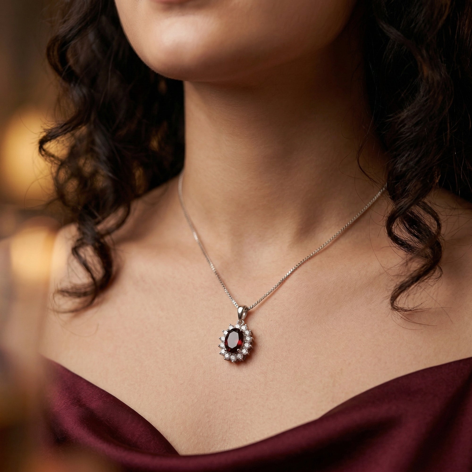 Model wearing the Odilia oval garnet necklace in sterling silver against a burgundy silk dress.