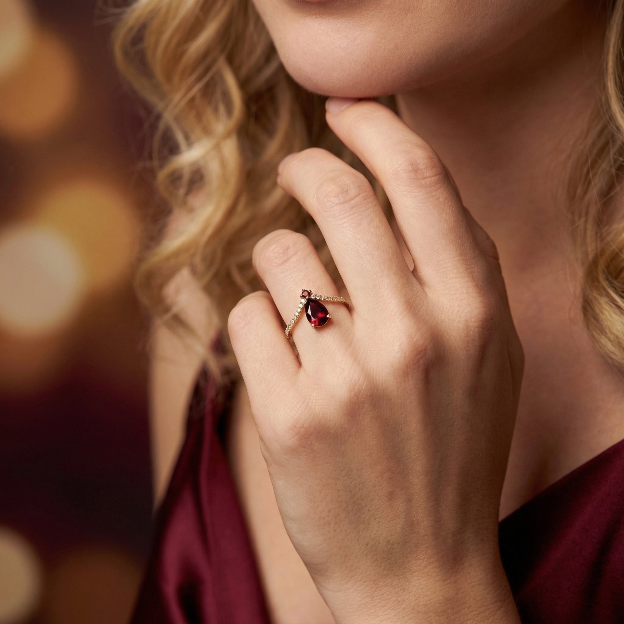 Model wearing the Ignis pear-cut garnet chevron ring in 18K gold vermeil on her ring finger.