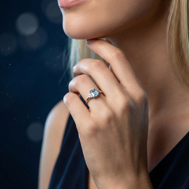 Woman wearing the emerald cut natural blue topaz sterling silver ring on her finger.