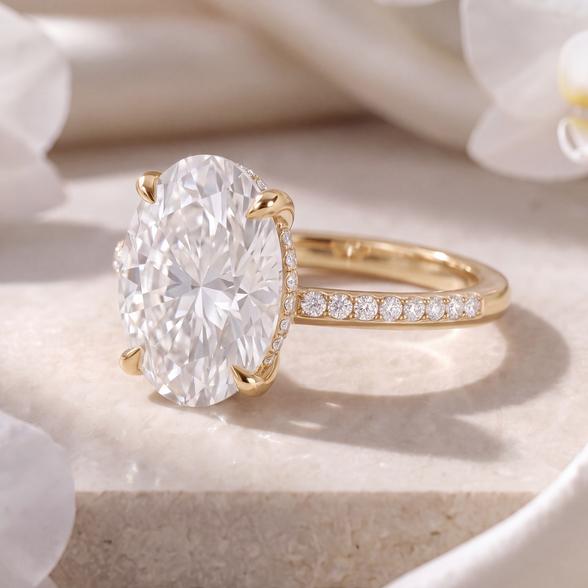 Side profile shot showing the hidden halo detail and claw prongs of the yellow gold oval moissanite engagement ring.