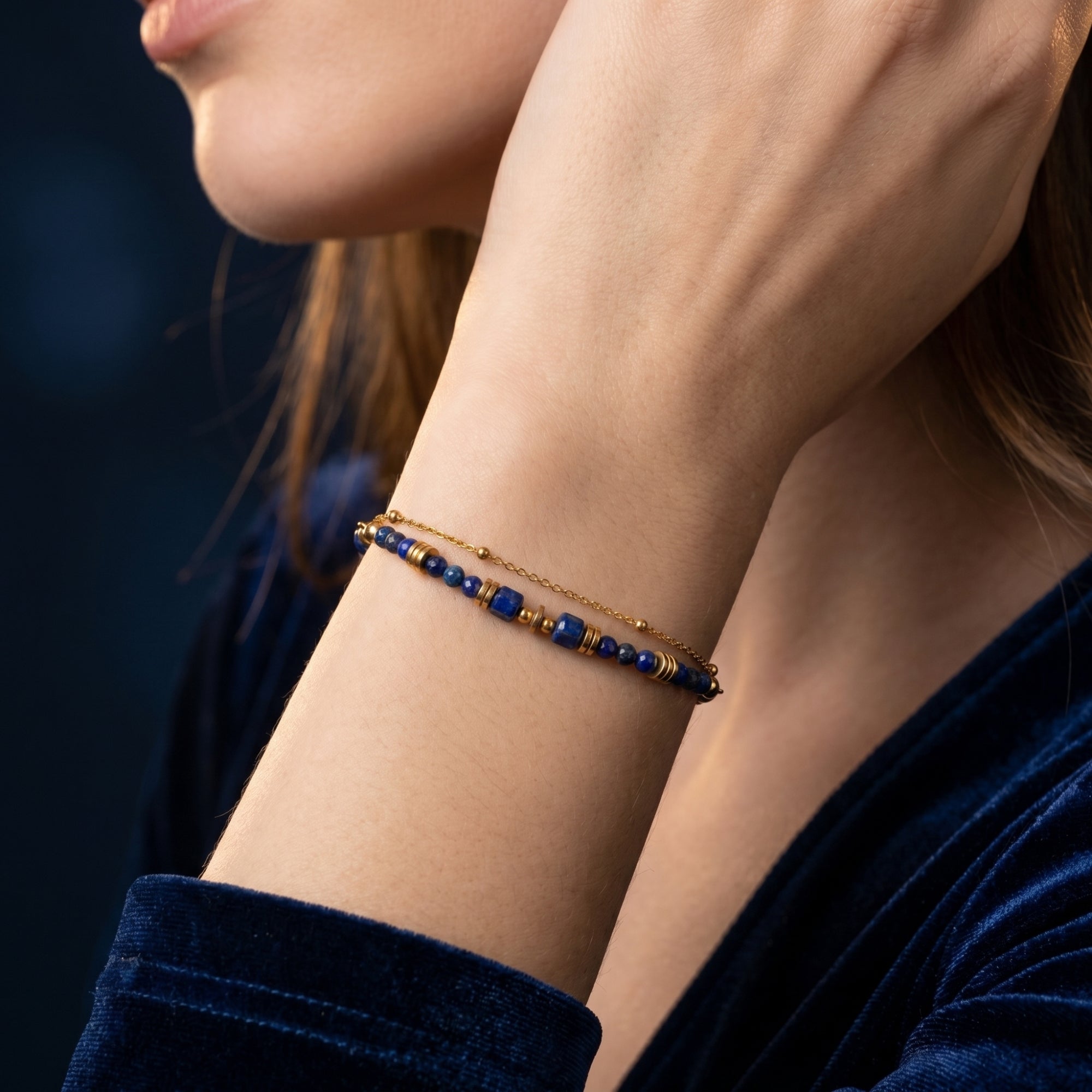 Double-layered 18K gold plated bracelet with blue lapis lazuli beads worn on a woman's wrist.