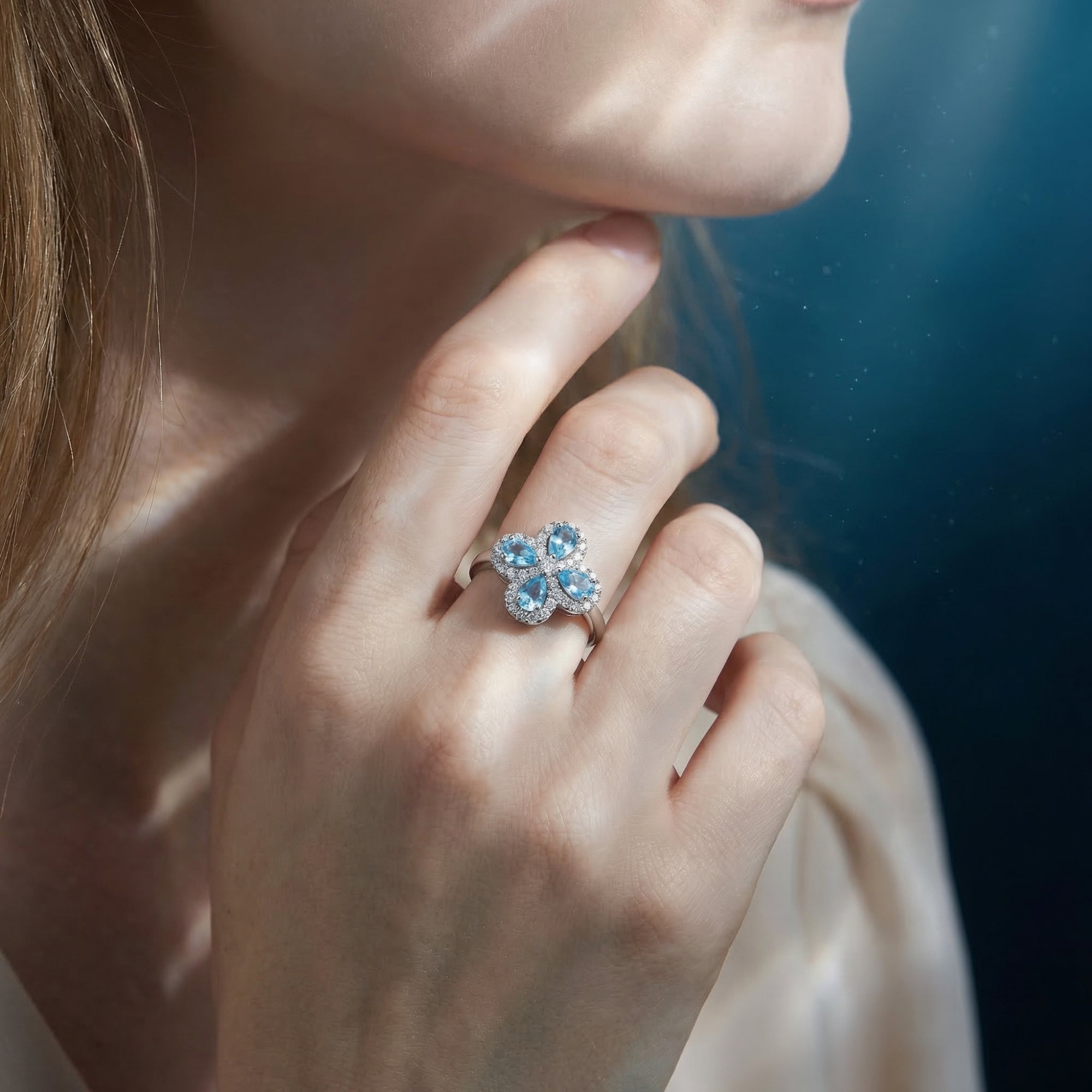 Woman wearing the silver aquamarine floral clover ring on her finger in a soft, lifestyle setting.