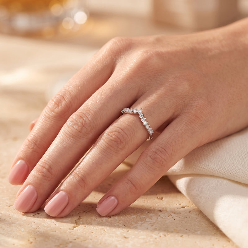 Silver chevron promise ring with cubic zirconia worn on a woman's finger.