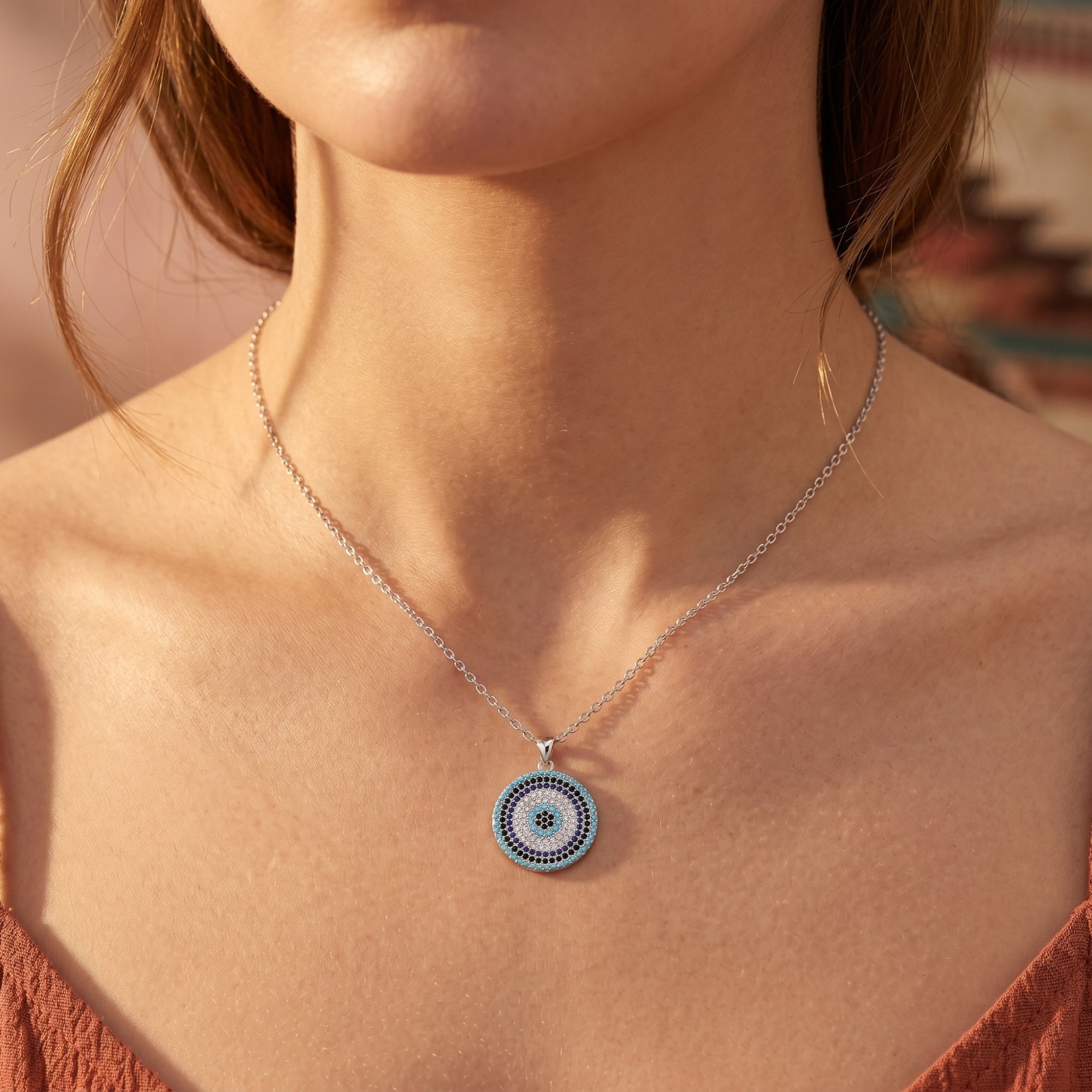 Southwestern-inspired silver necklace with a circular turquoise pendant worn by a model.