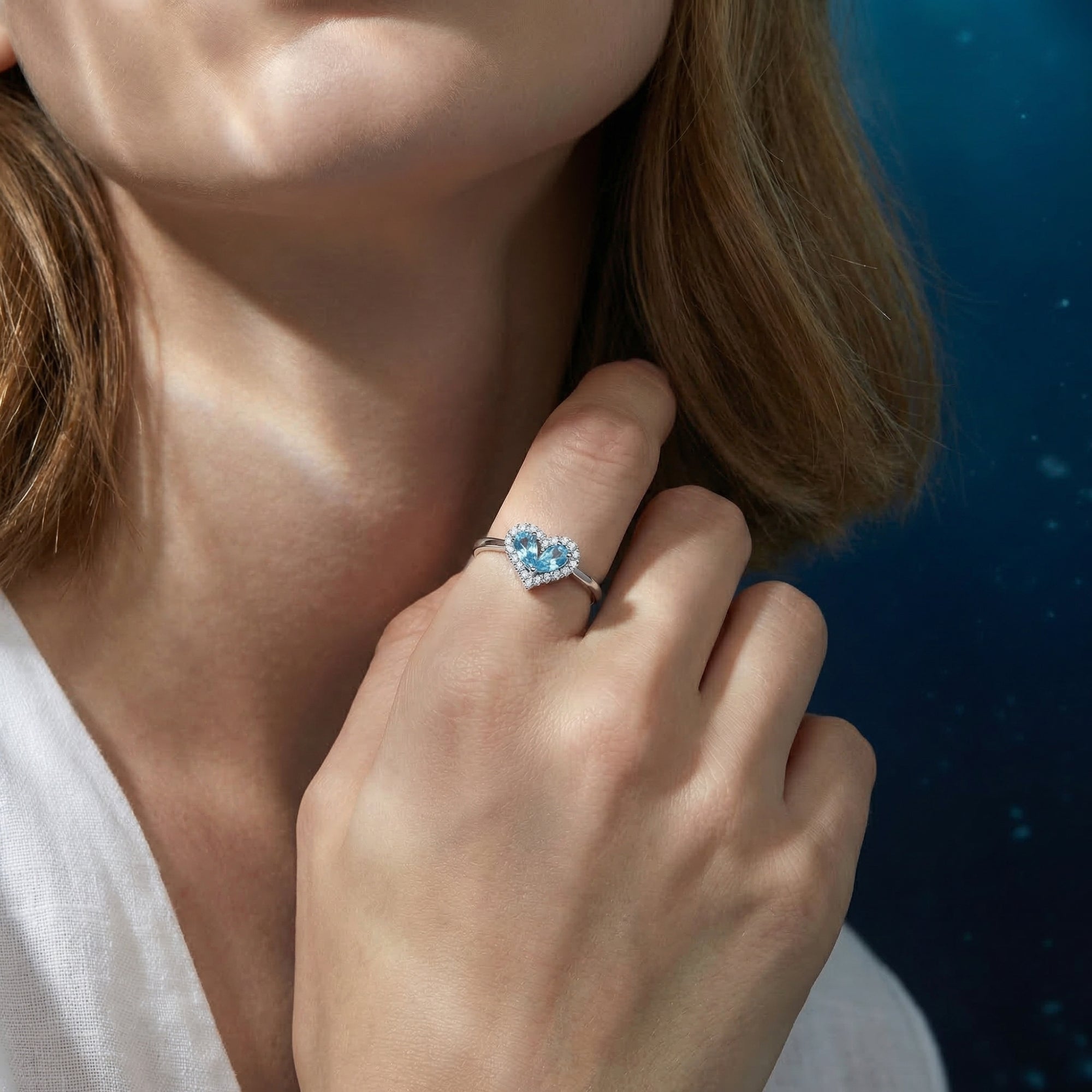 Model wearing the heart-shaped natural aquamarine halo ring in white gold on her finger.