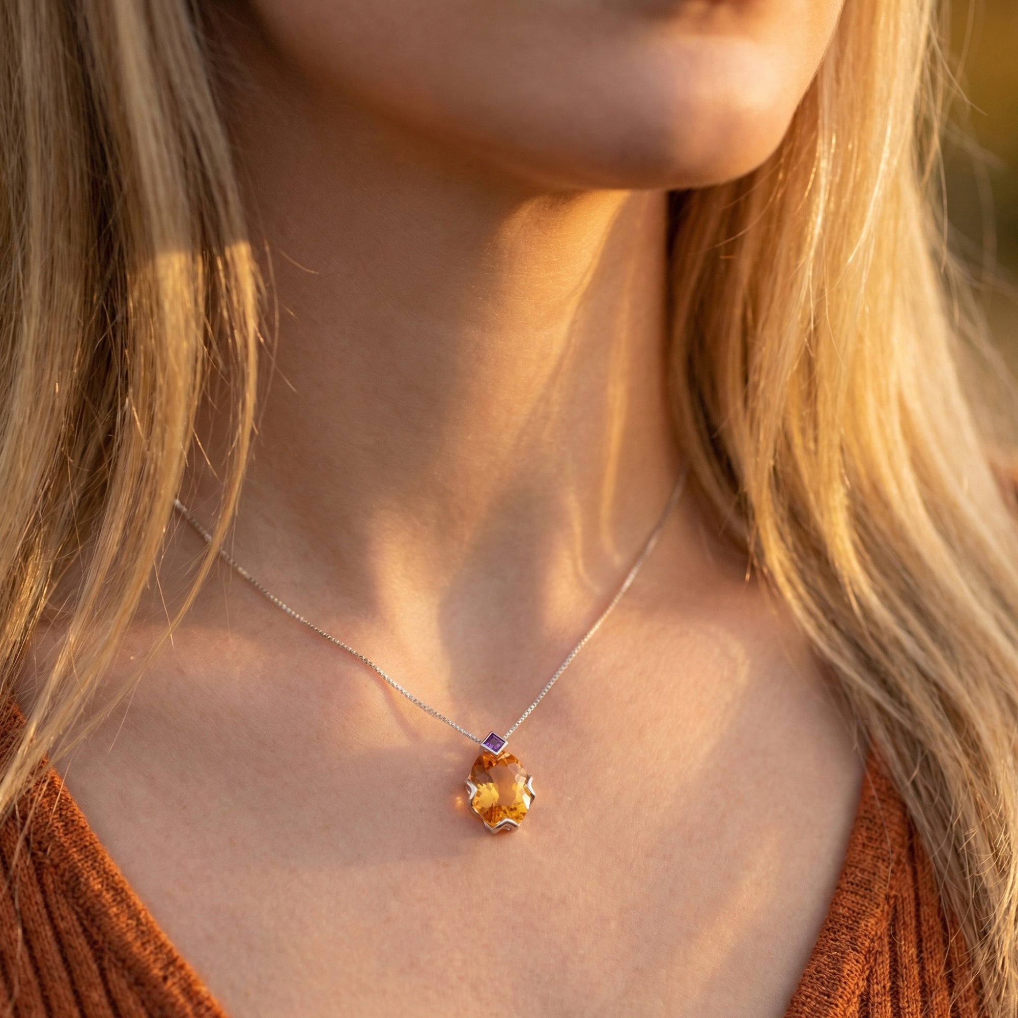 Model wearing the Celestria citrine necklace featuring an oval-cut pendant and silver chain.